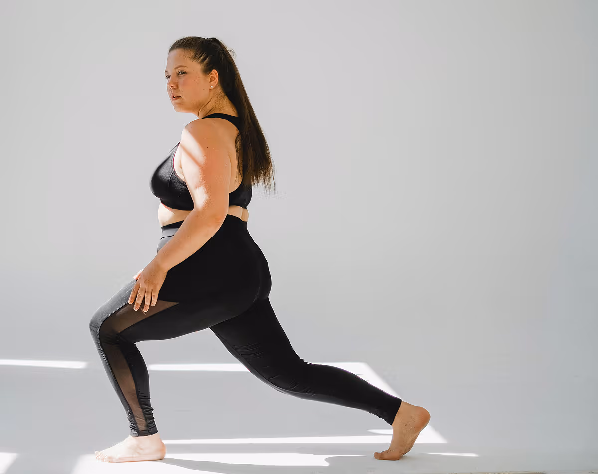Confident woman in black fitness outfit after GLP-1 weight loss therapy with Hedfirst.