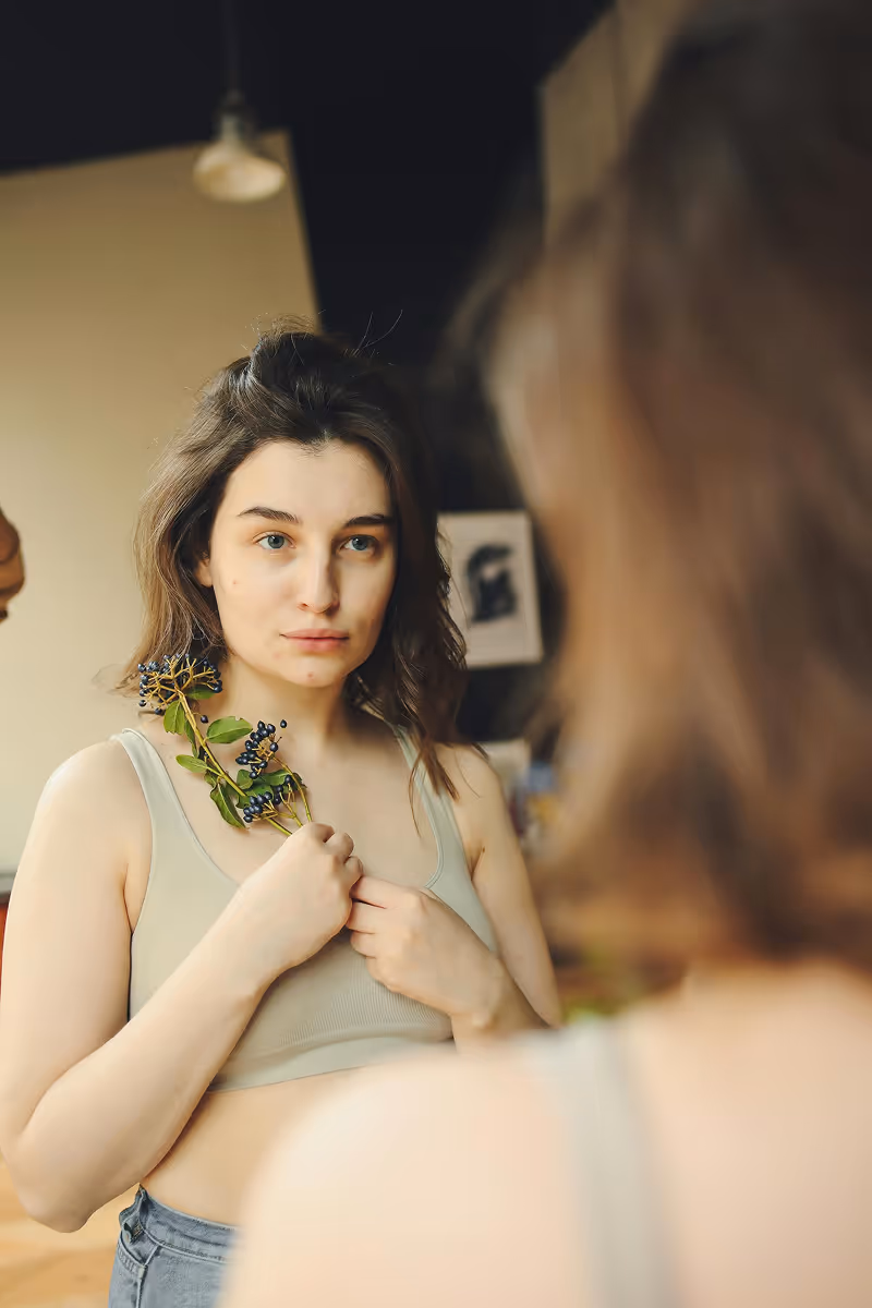 Woman holding a flower symbolizing natural thyroid health support with Hedfirst treatments.