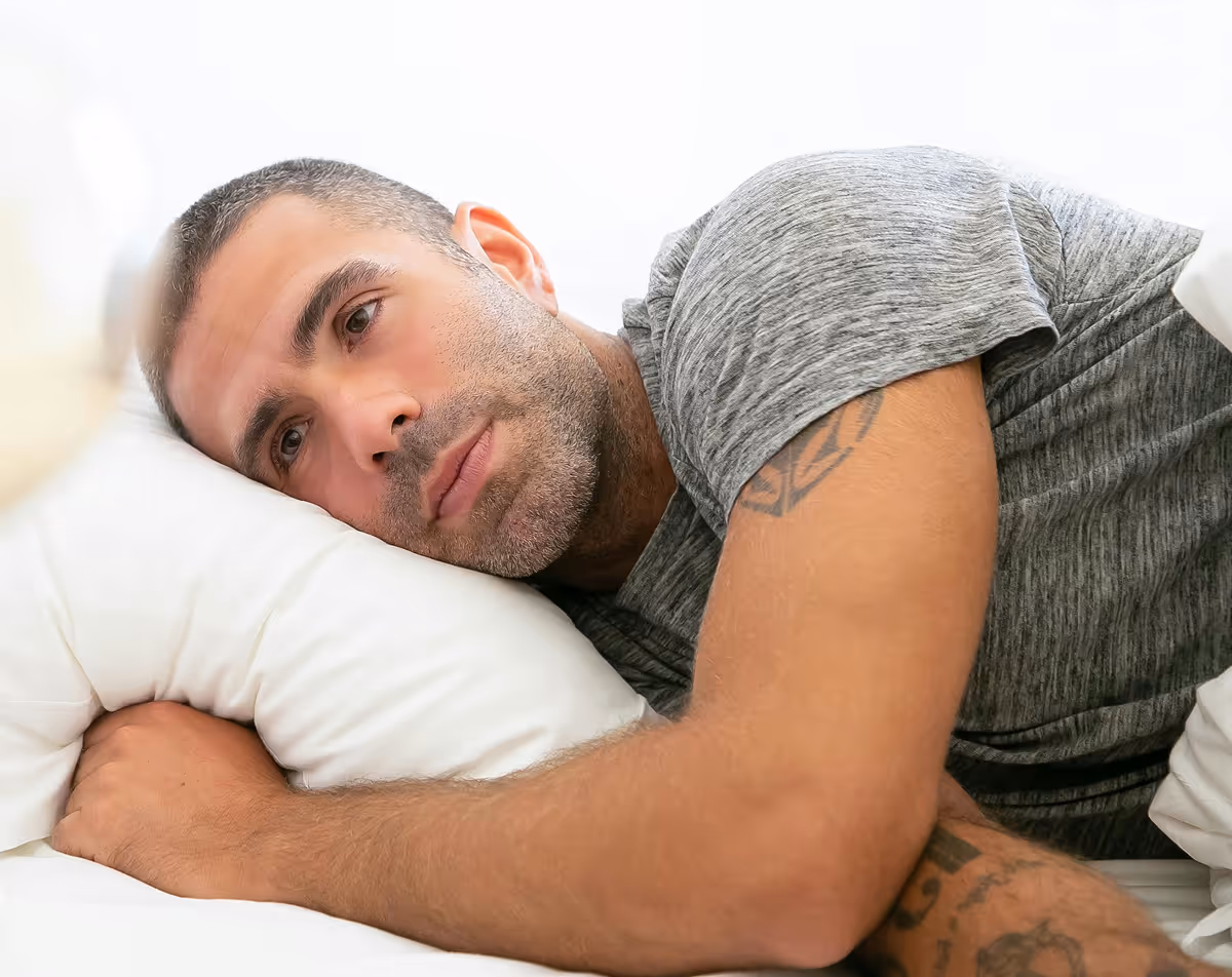 Man resting in bed after starting Hedfirst sleep treatment.