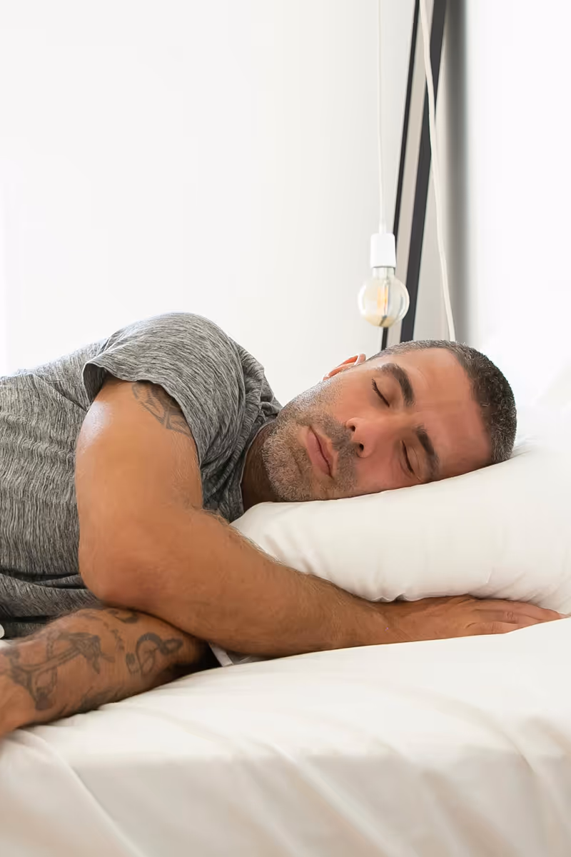 Man sleeping peacefully with sleep apnea treatment support by Hedfirst.