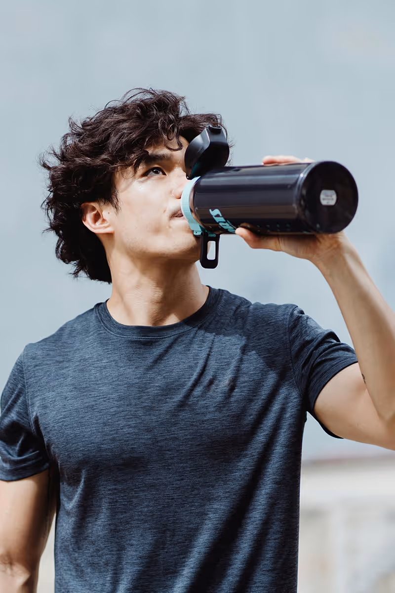 Man drinking water from sports bottle after workout.