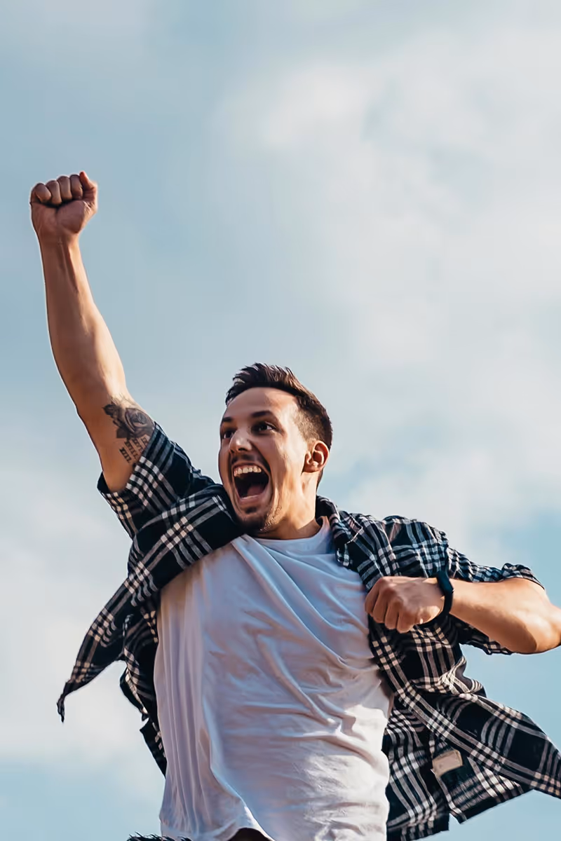 Man celebrating energy boost outdoors after treatment — Hedfirst vitality and stamina support.