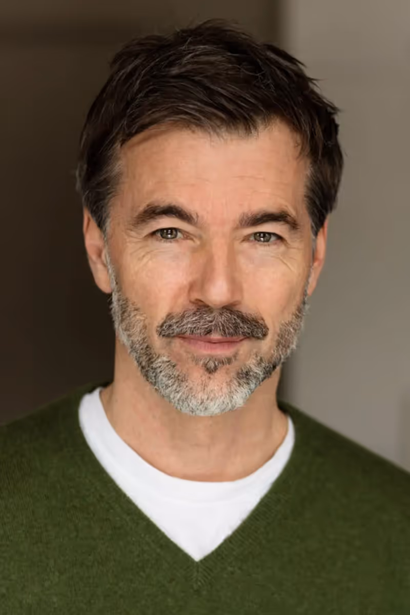 Man smiling confidently after hair thinning treatment.