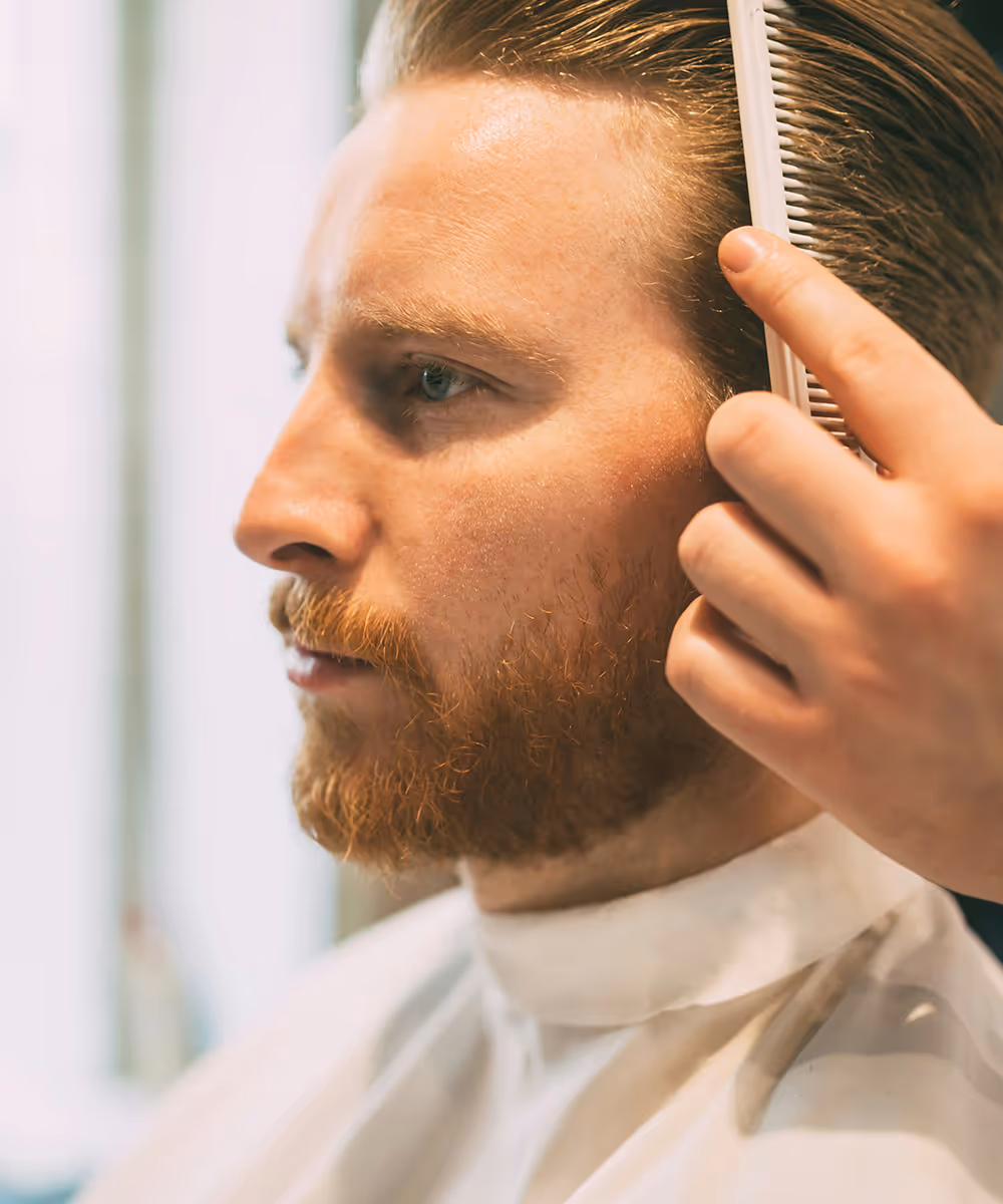 Man getting hair checked for hair loss treatment.