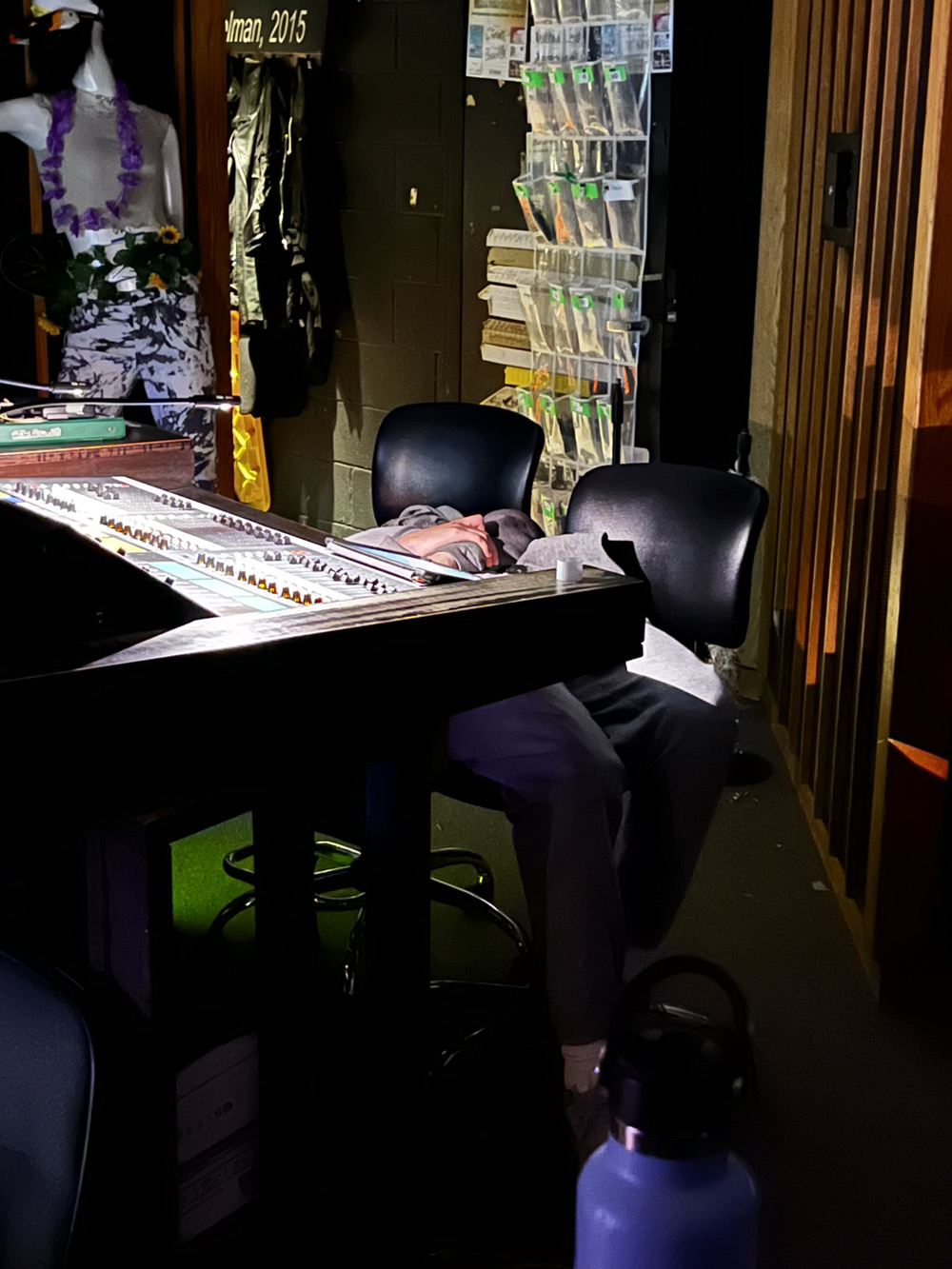 A look at our soundboard with our mic holder in the background. For non-show times all of our mics live in cases but for shows we take them out and put them in labeled pocket so they are ready. 