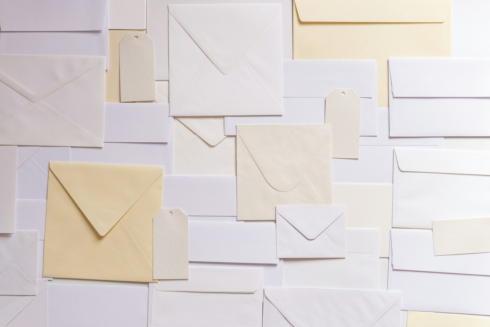 Overhead view of white, grey, and cream paper envelopes scattered across a surface