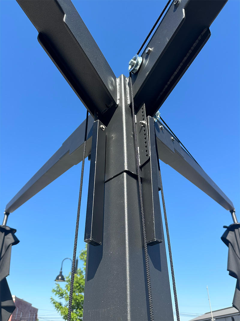 Close-up of a black metal structure with cables, set against a clear blue sky.