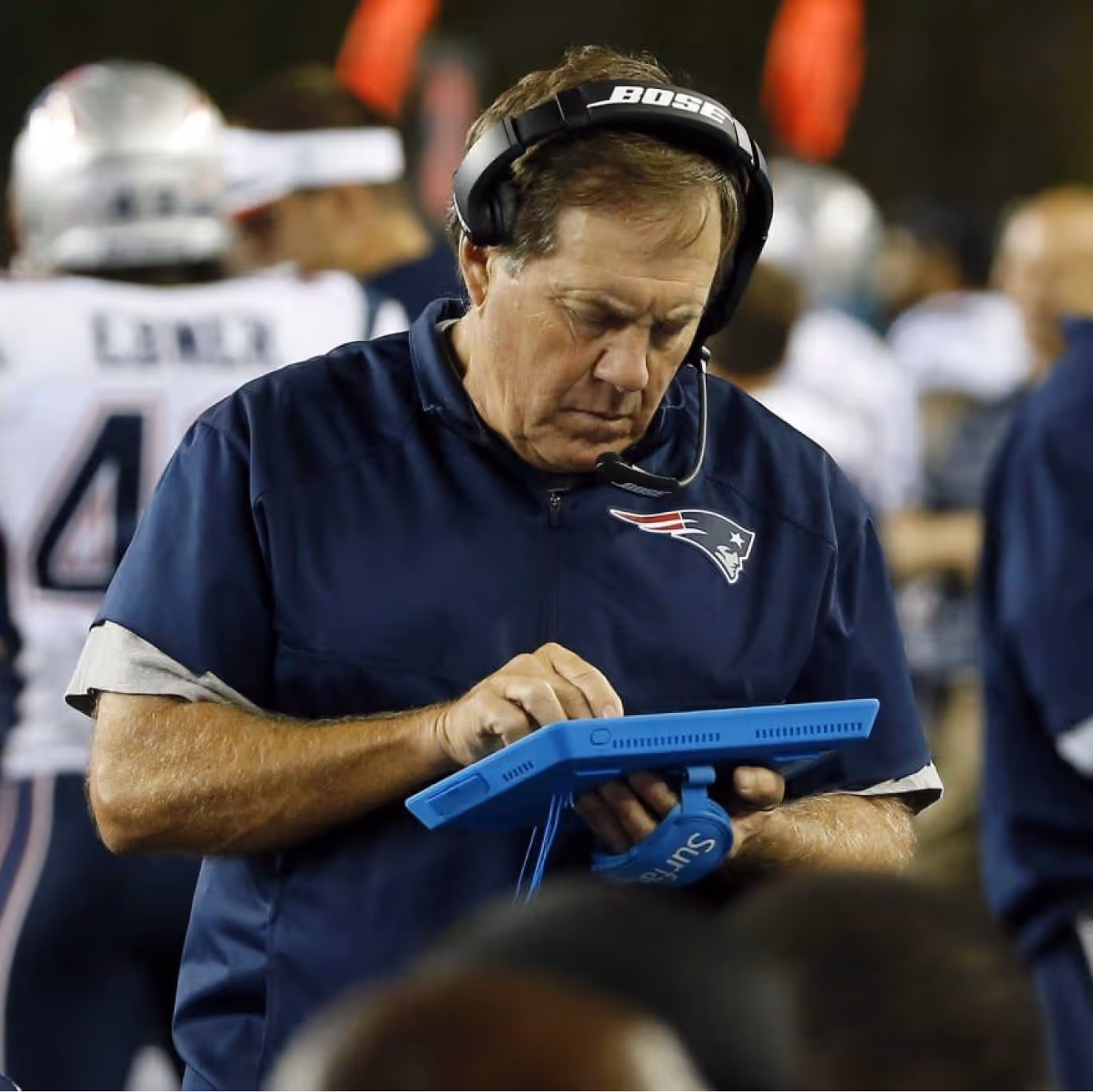 NFL coach reviewing real-time game data on a Microsoft Surface tablet powered by Verizon technology