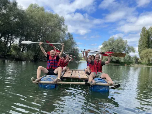 Ein Team auf dem fertig gebauten Floß im Wasser