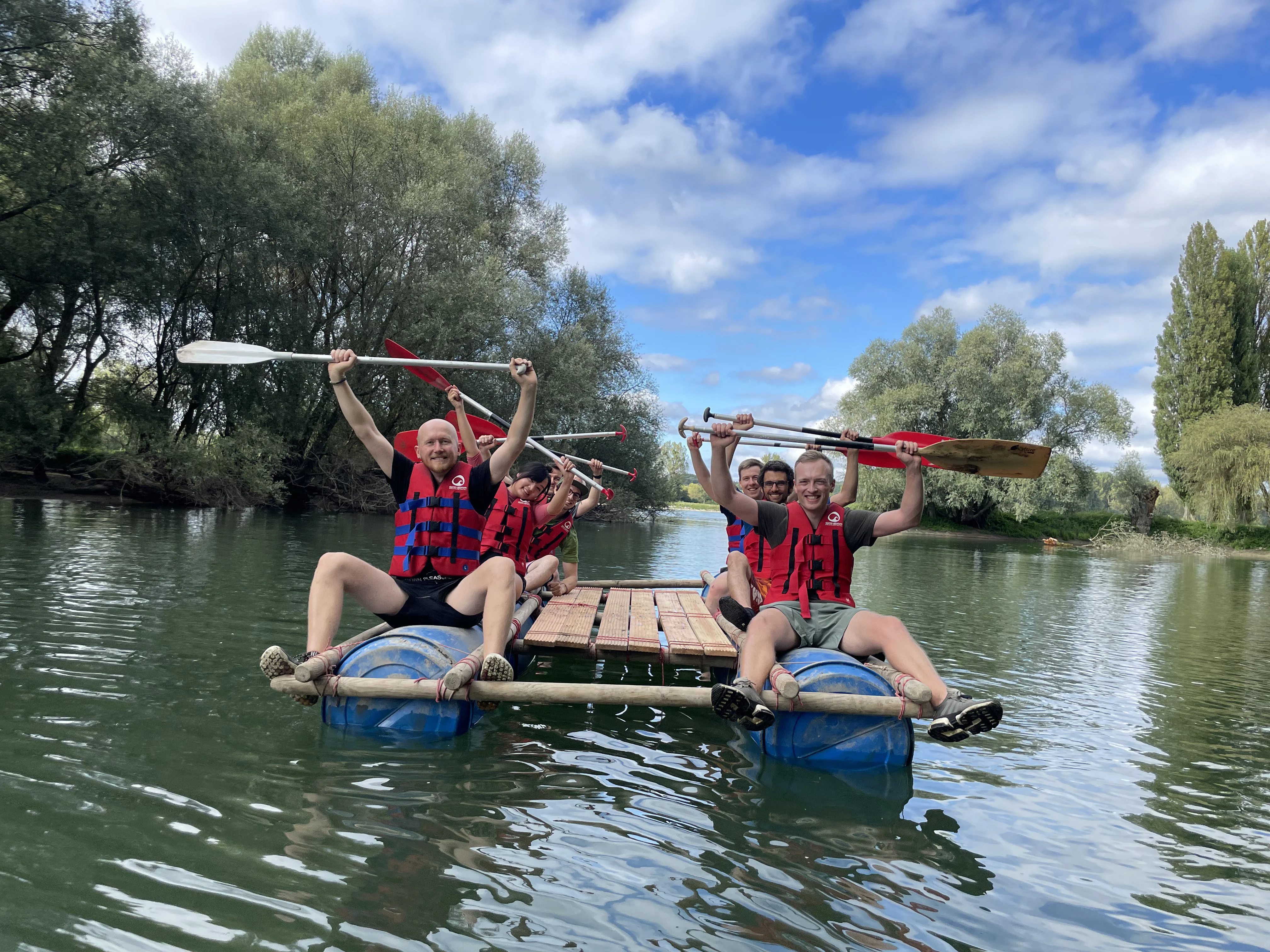 Ein Team auf dem fertig gebauten Floß im Wasser