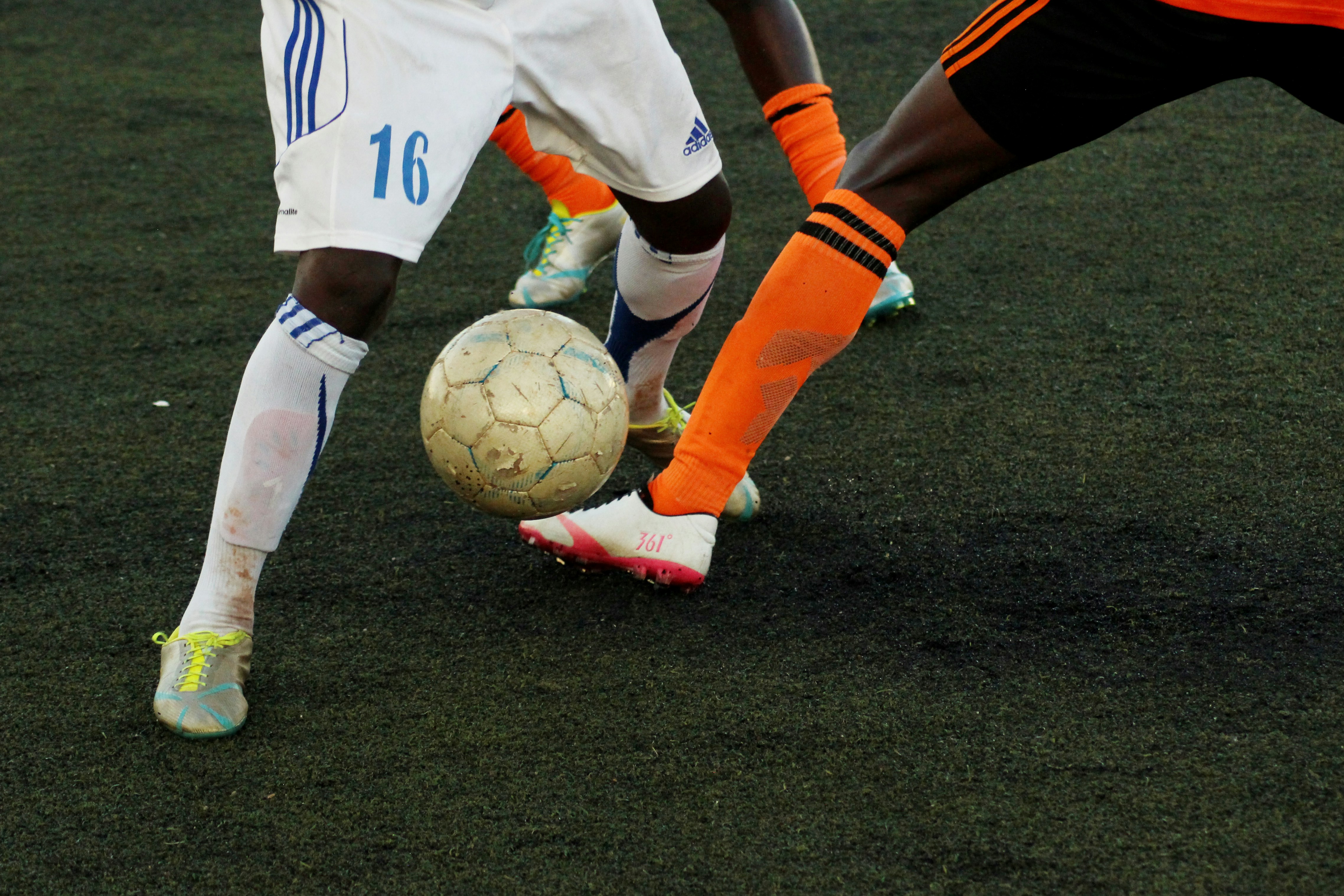 Nahansicht von den Beinen zweie Fußballspieler mit Ball