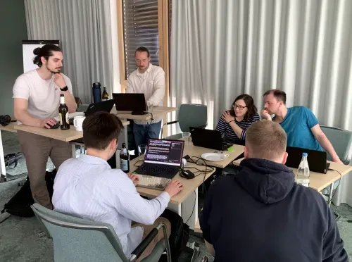Ein Gruppe abeitet gemeinsam an eine Gruppentisch an Skill-Services