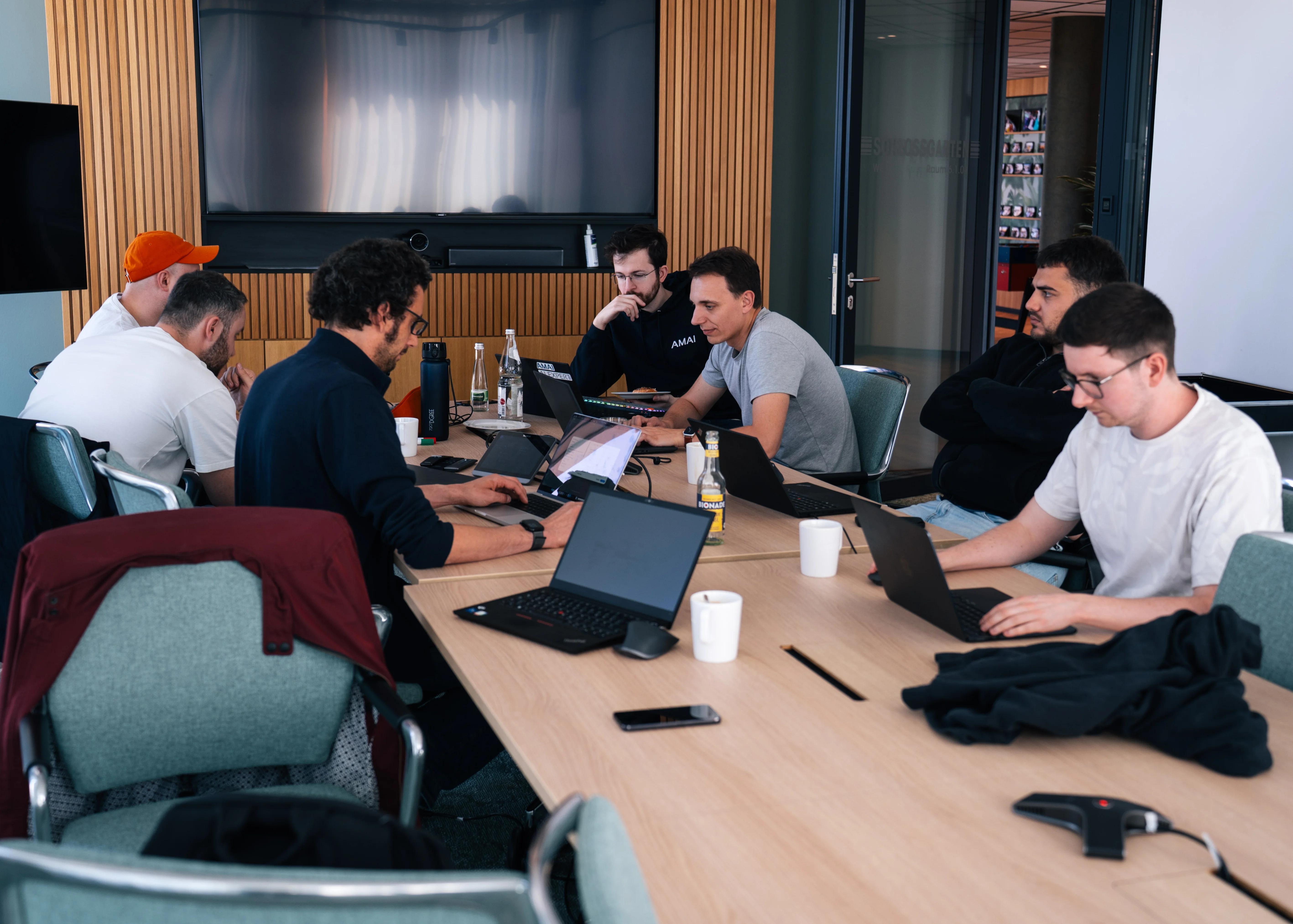 Eine Gruppe beim Arbeiten an Laptops an einem Besprechungstisch