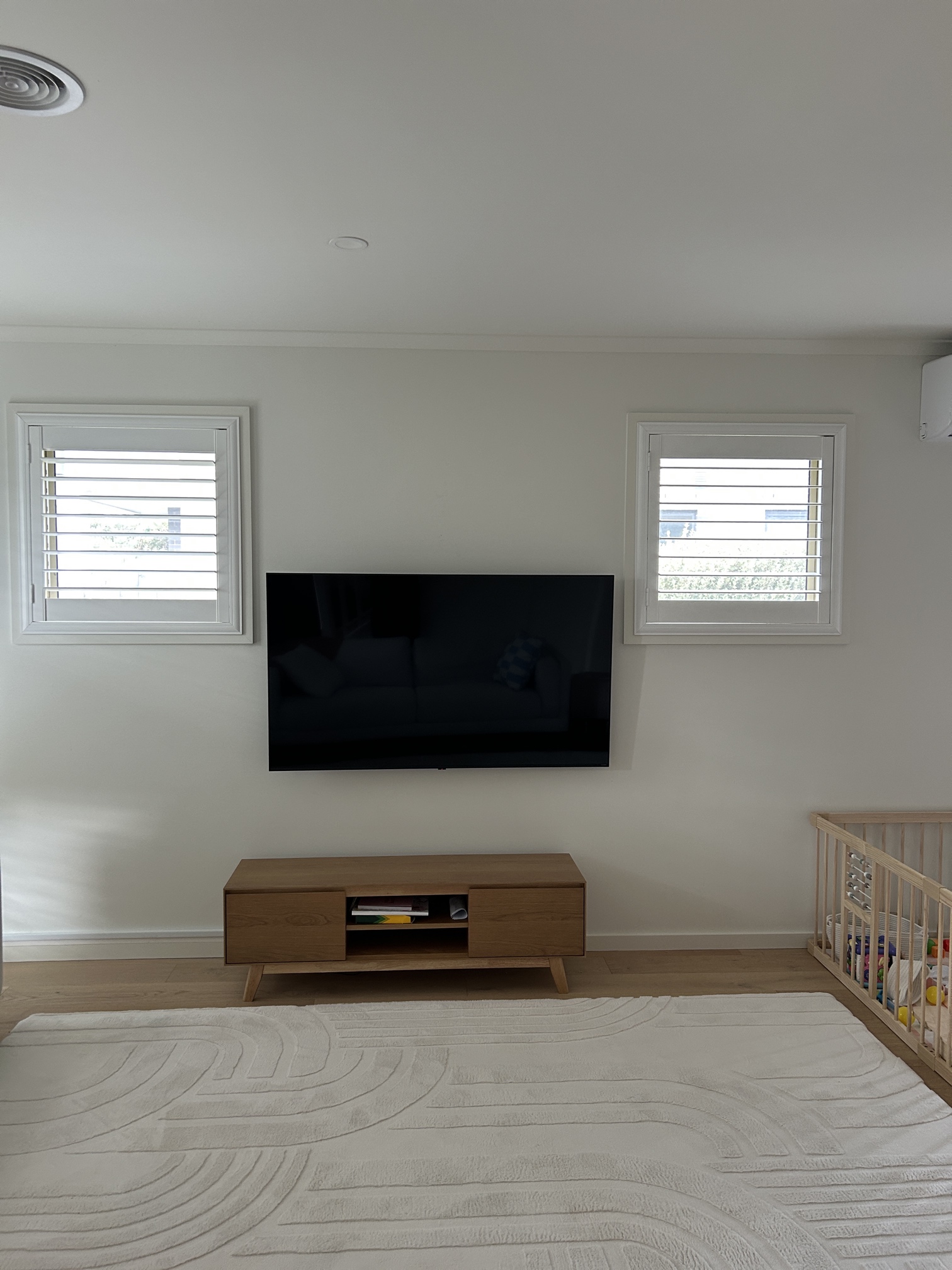 Electrician mounting TV on wall and installing power point in Edithvale living room