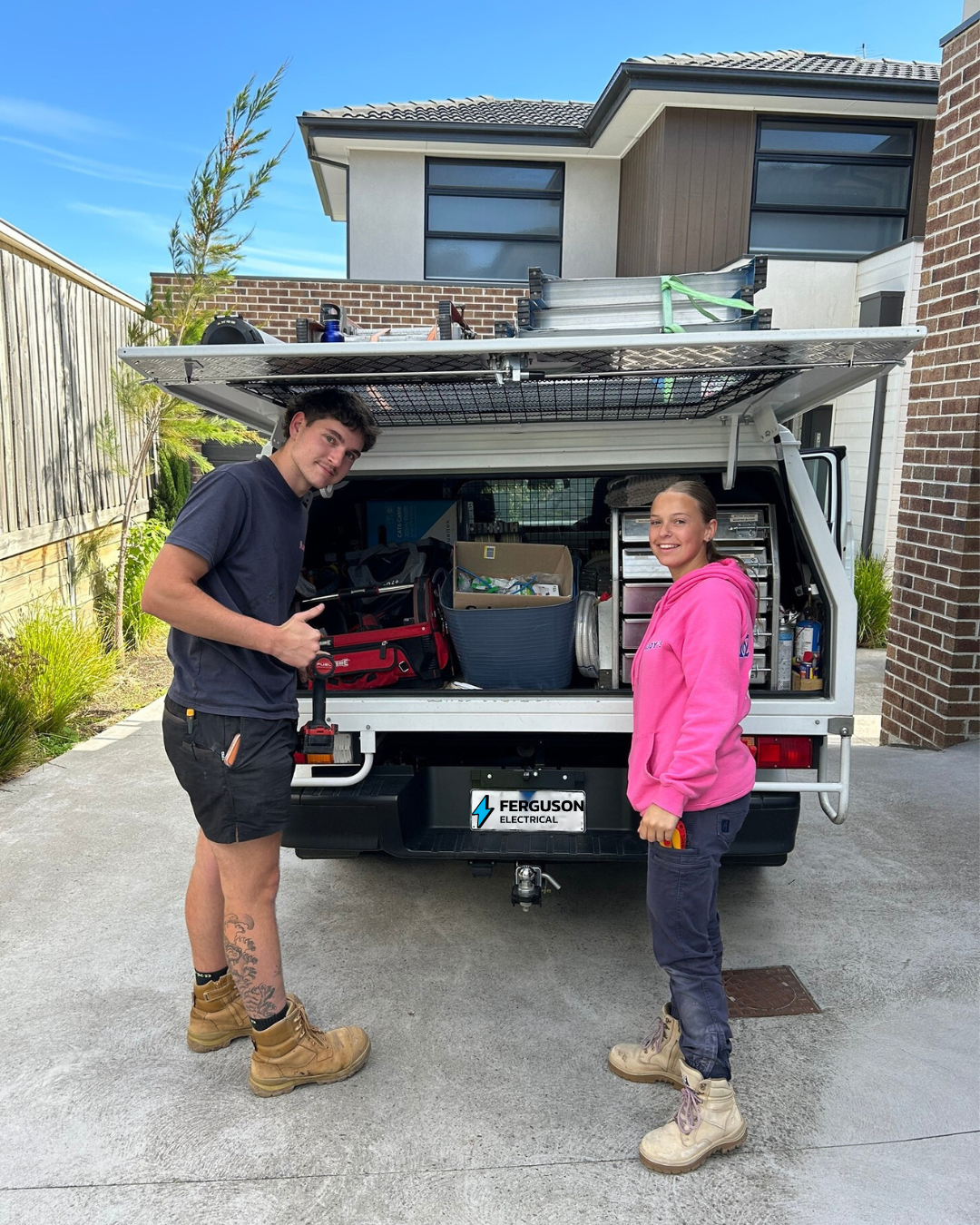 Ferguson Electrical apprentices Jordan and Tylah smiling beside their work vehicle after completing data and power upgrades in Frankston.