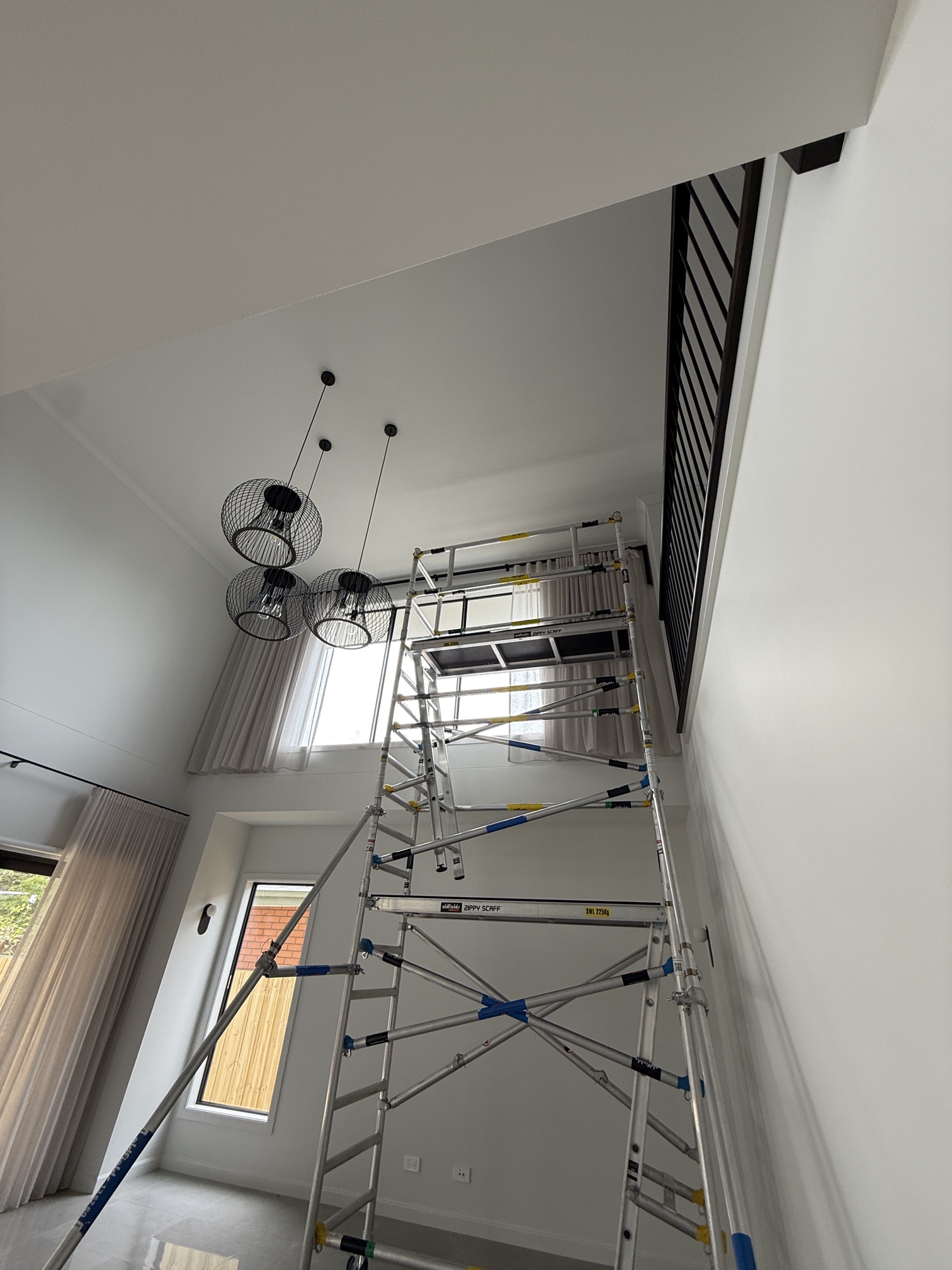 Scaffolding and electrical power installation for automated blinds in a double-storey Forest Hill home.