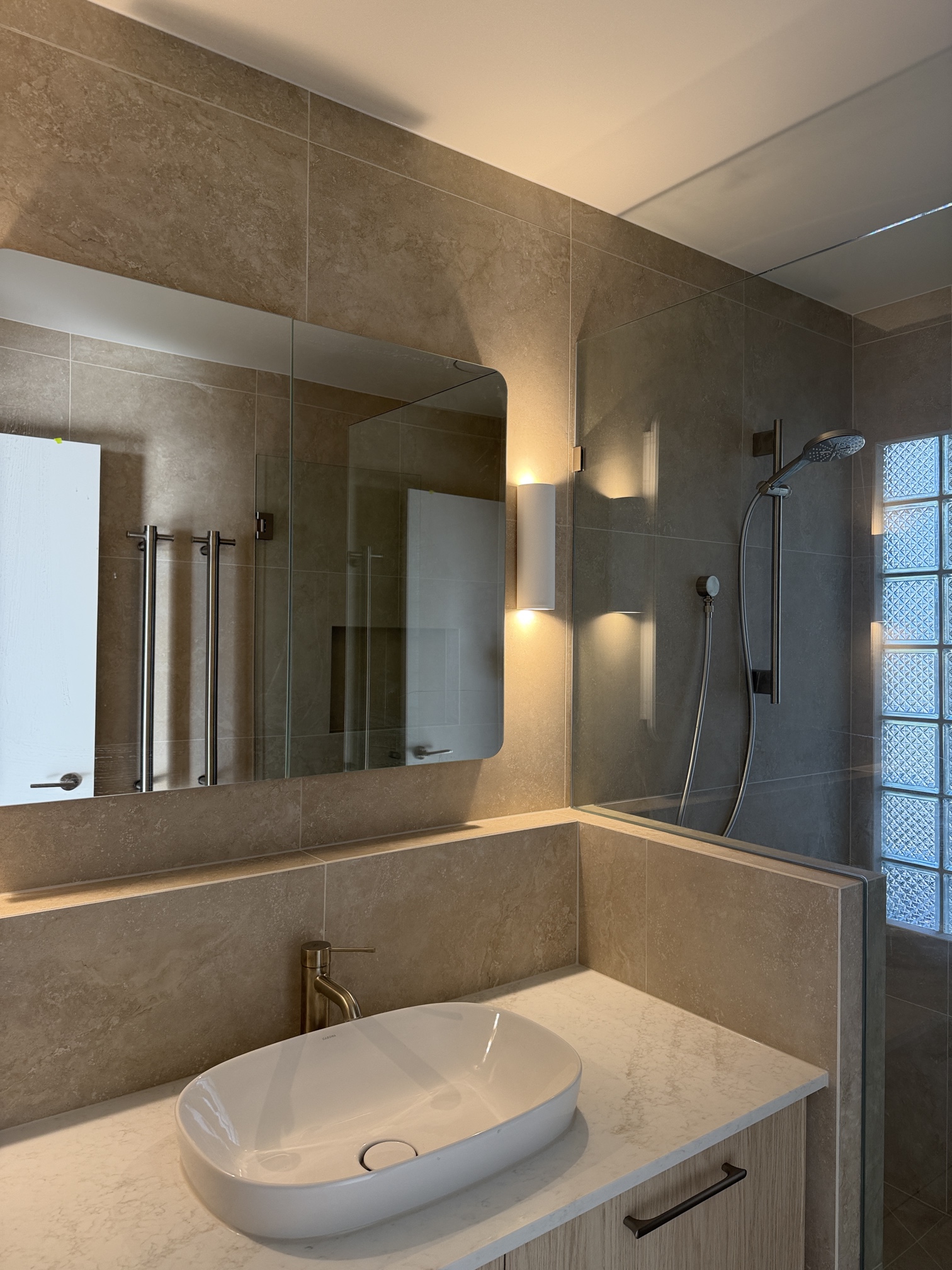Modern renovated bathroom in Rye featuring architectural wall lighting, LED vanity lighting and premium electrical fit-off by Ferguson Electrical.