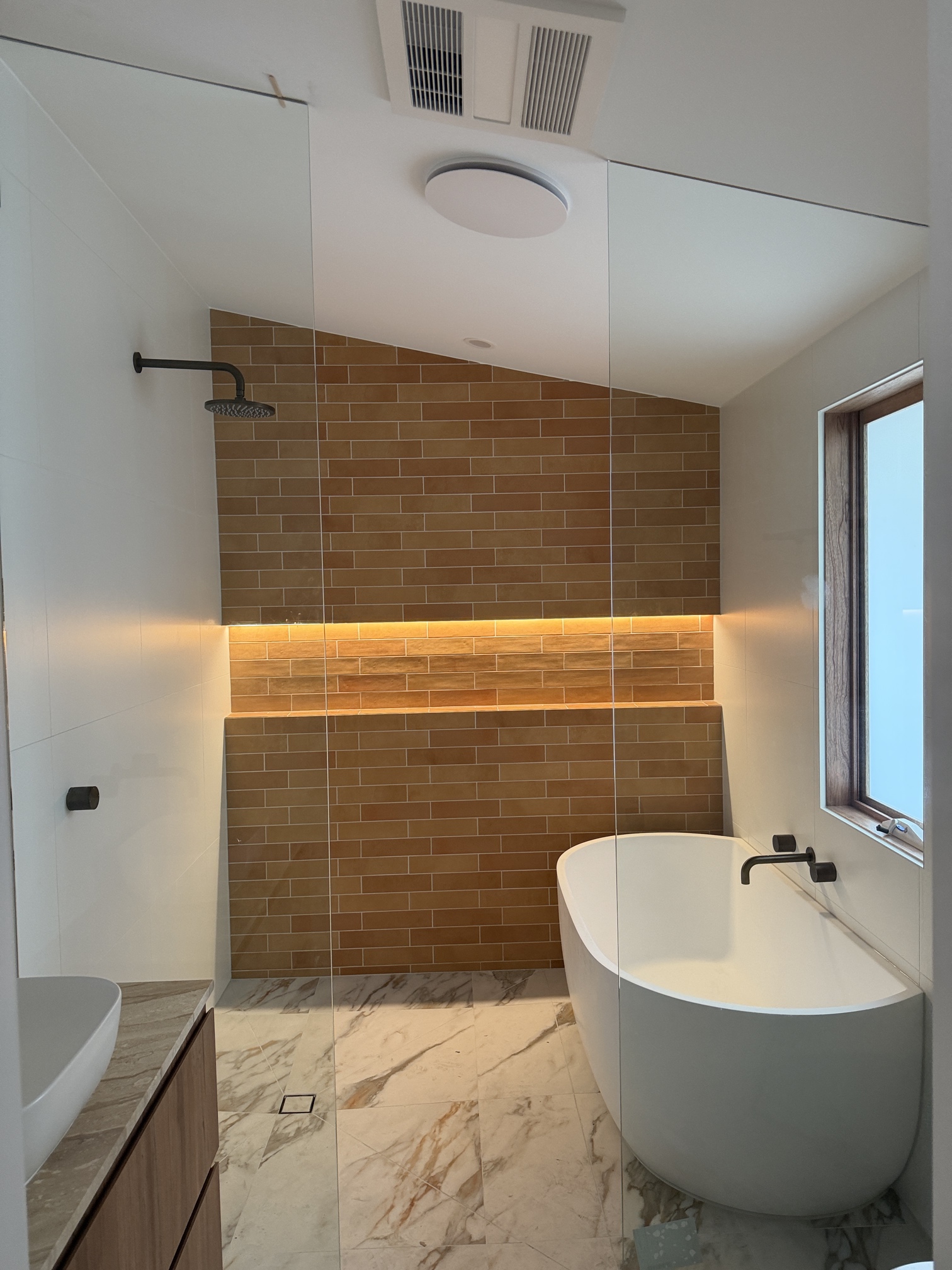 Modern bathroom renovation in Bonbeach featuring LED strip lighting, downlights and electrical installation completed by Ferguson Electrical.