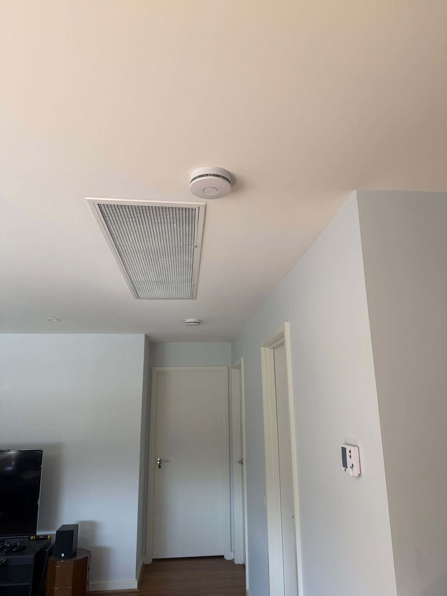 Electrician replacing an out-of-date smoke alarm in a Carrum home