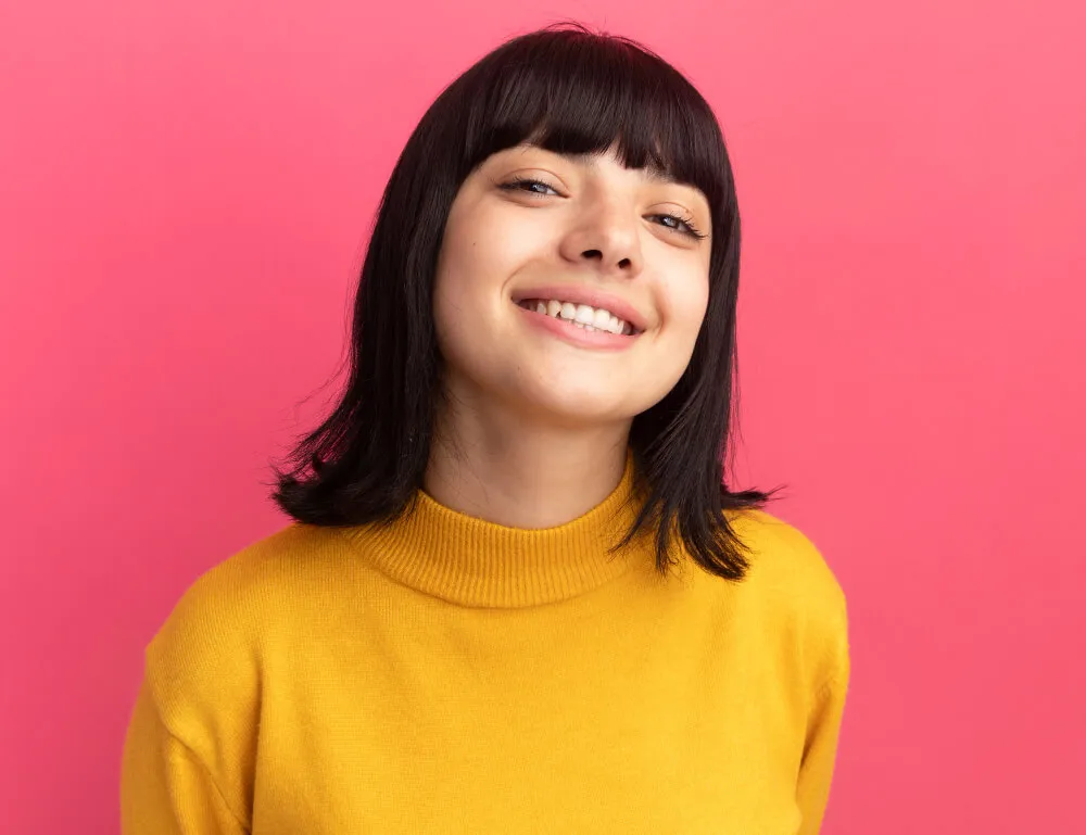 Smiling young woman on a pink background