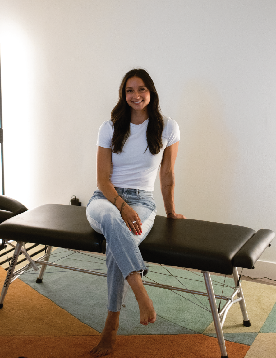Liv the chiropractor sitting on her adjusting table