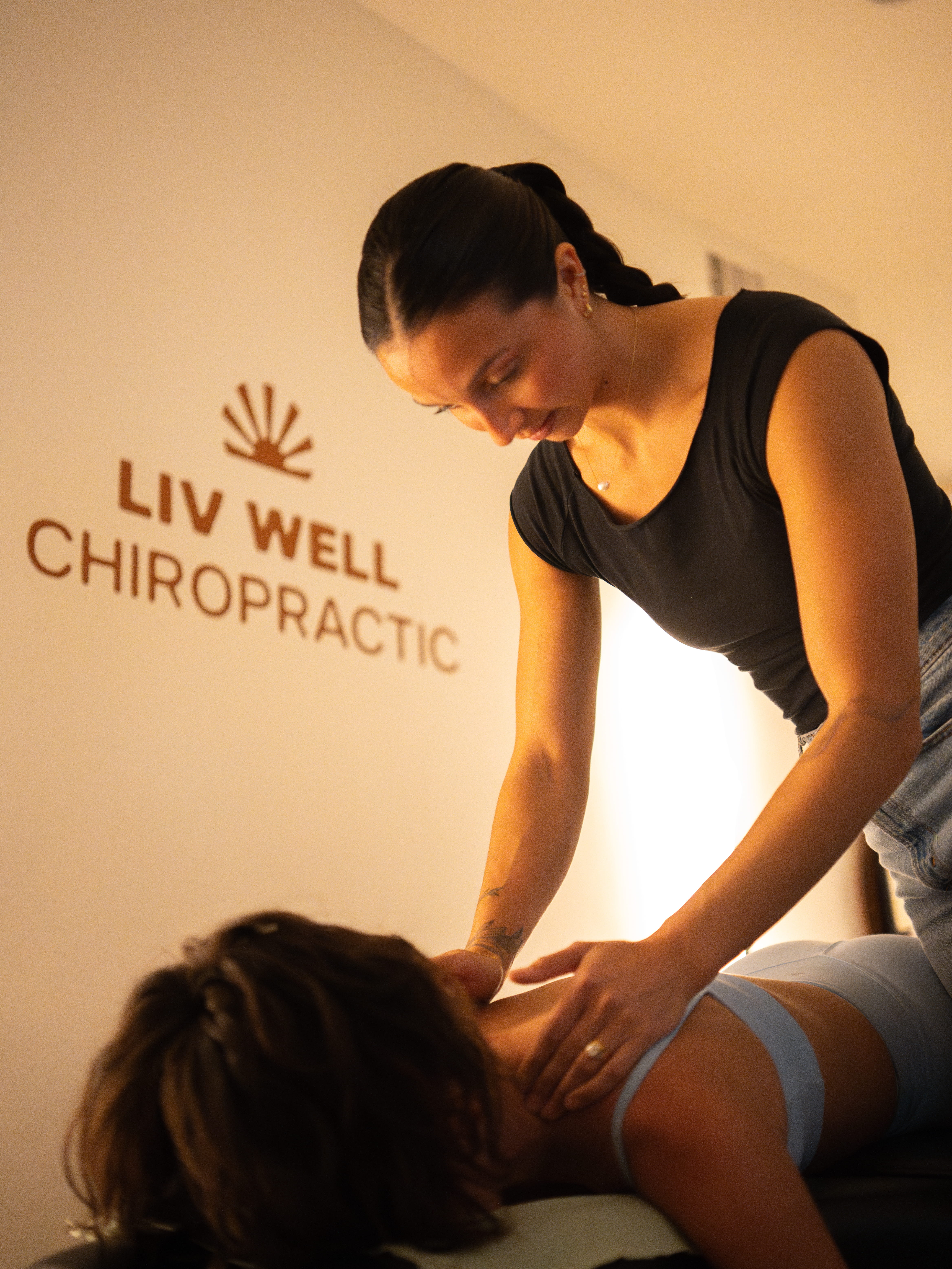 Liv the chiropractor sitting on her adjusting table