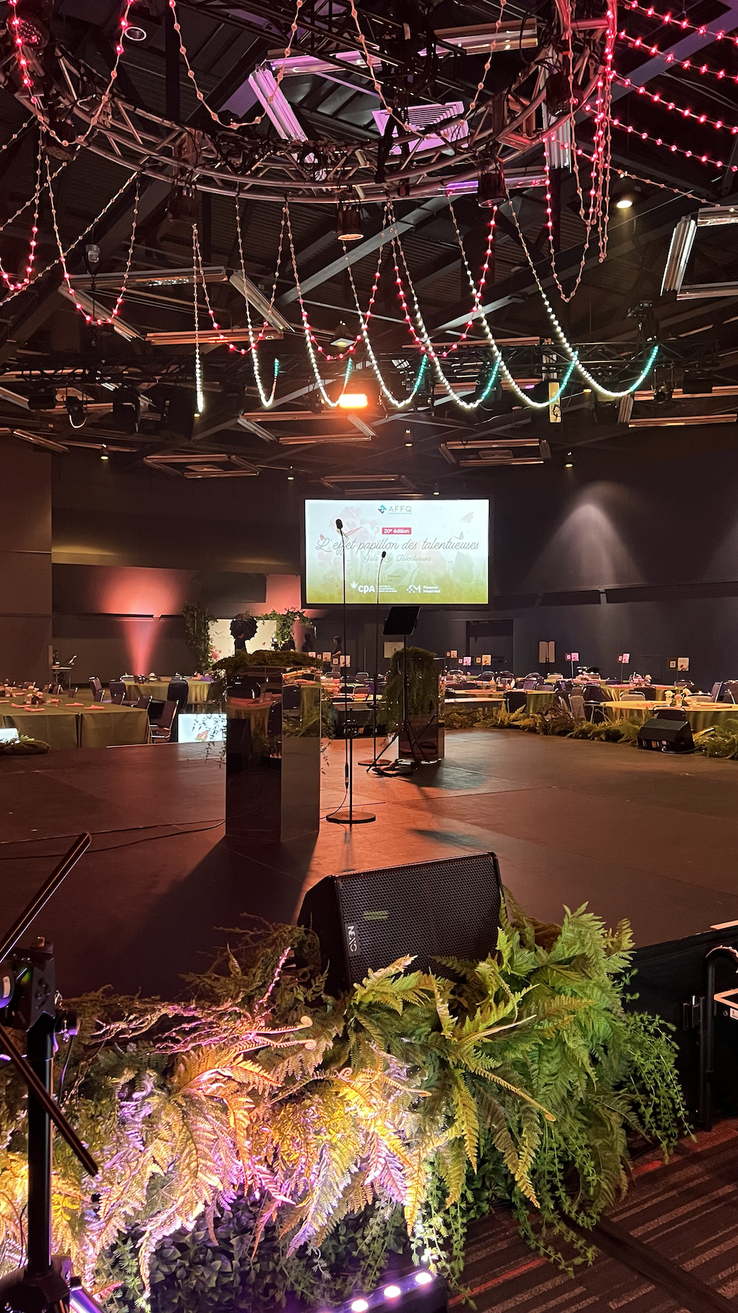A large room with a stage and a large screen.