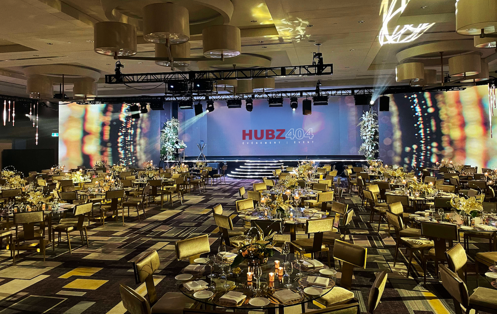 A large room with a stage and a large screen with the words Hubz 400 on it.