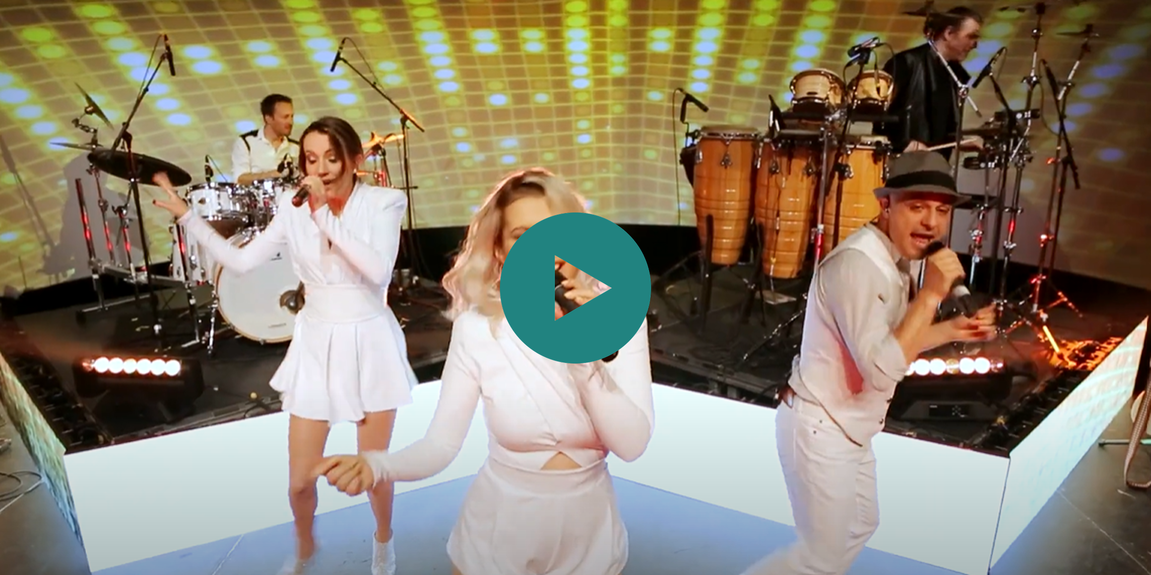 A woman in a white dress is singing into a microphone.