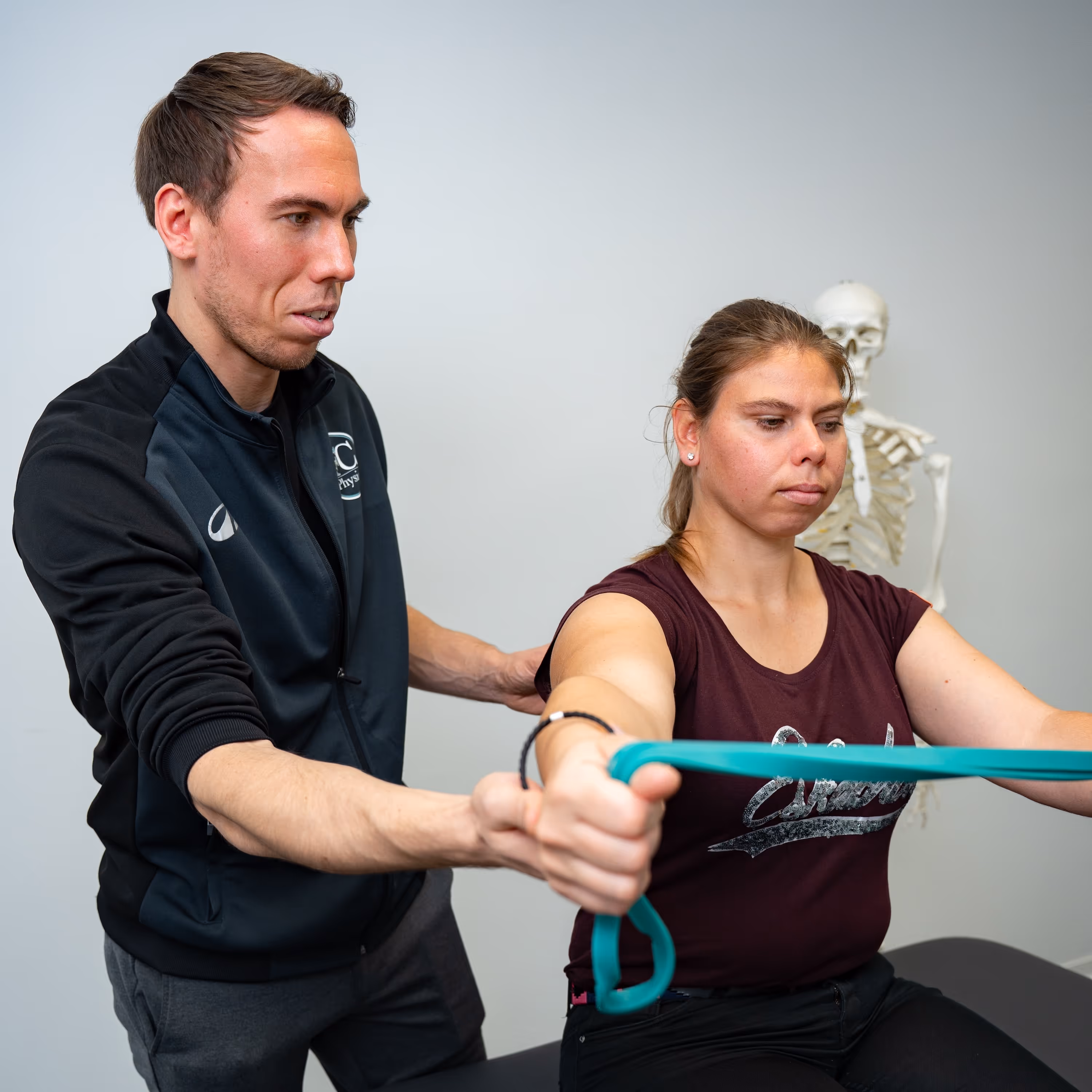 Ein Physiotherapeut therapiert eine junge Frau.