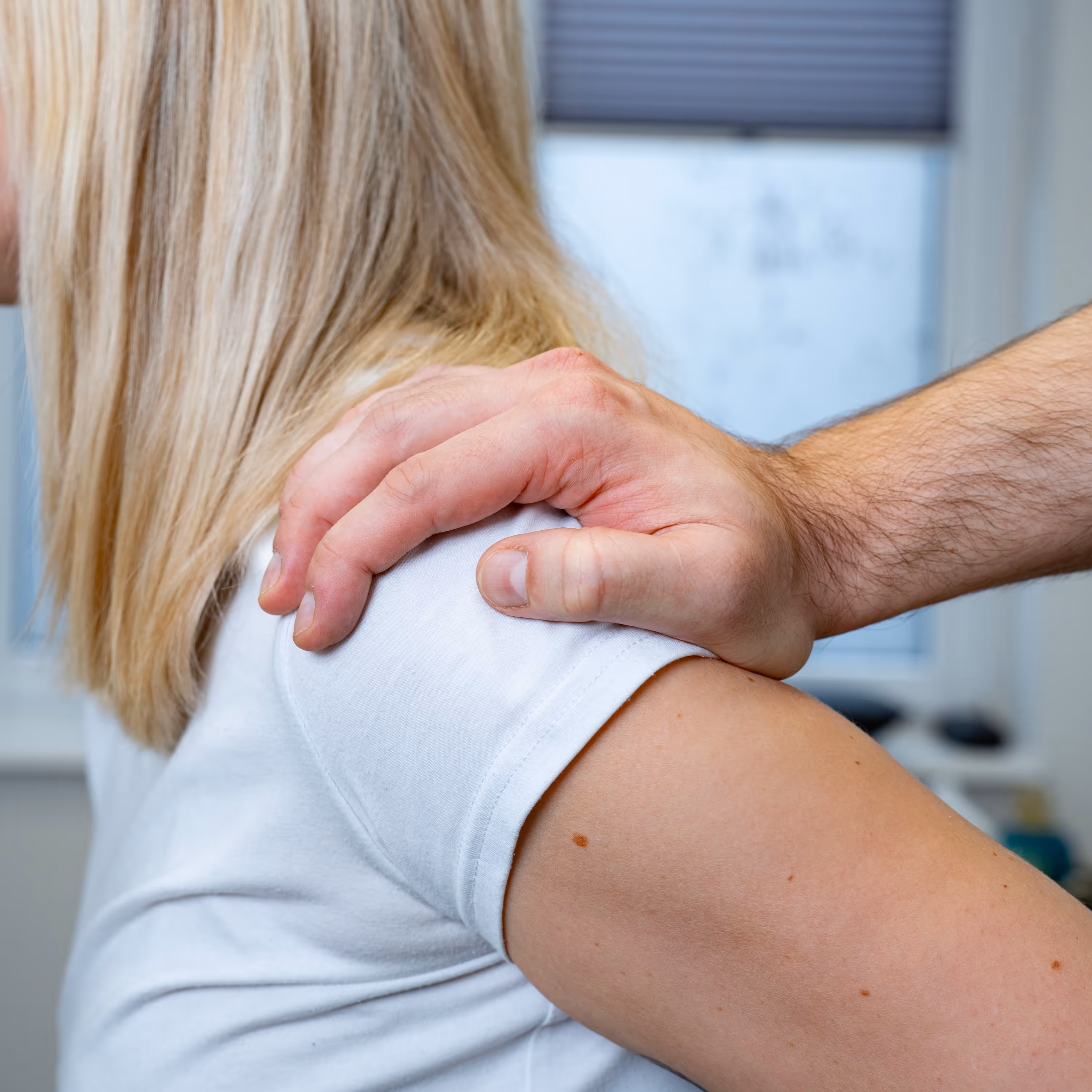 Ein Physiotherapeut therapiert eine junge Frau.