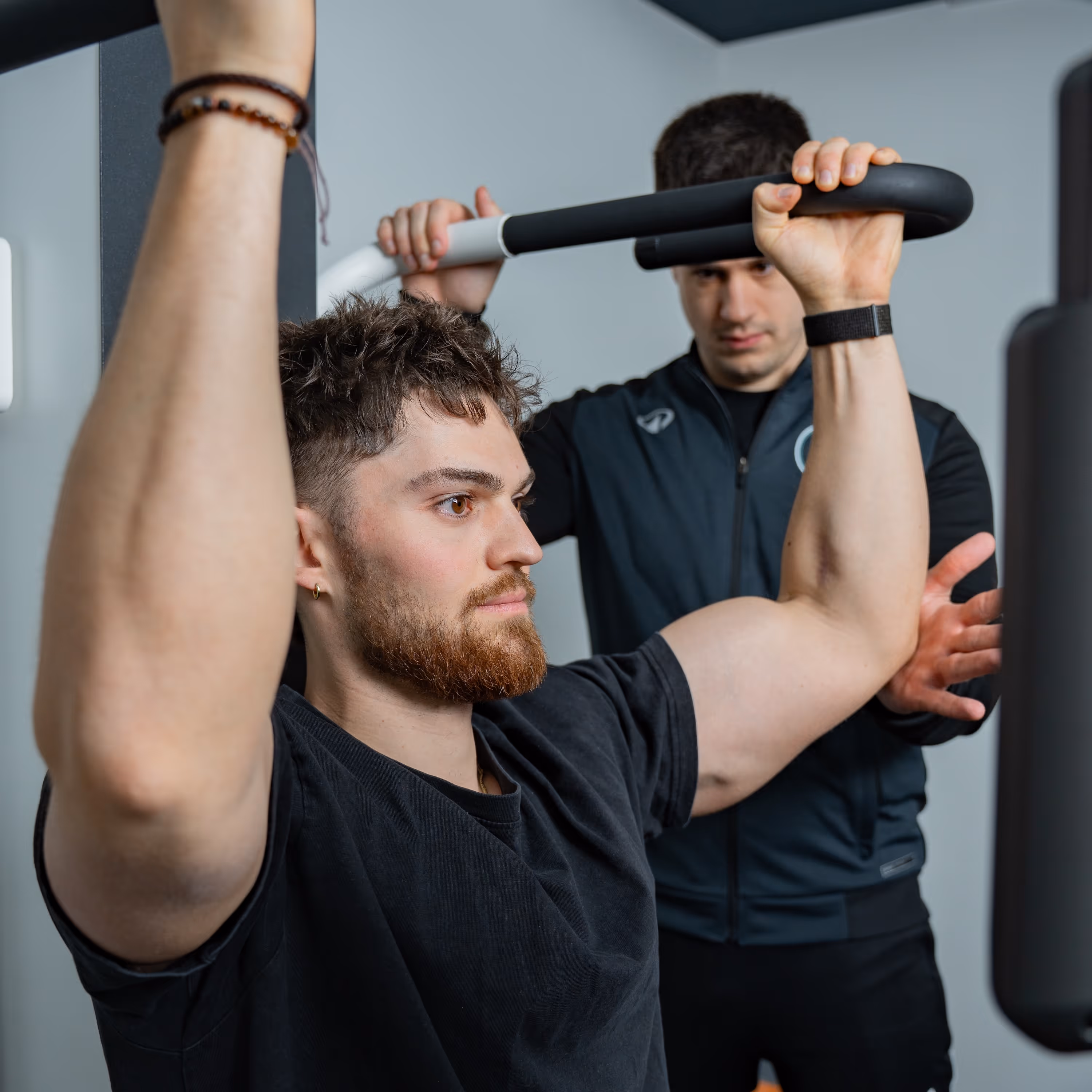 Ein Physiotherapeut therapiert einen jungen Mann.