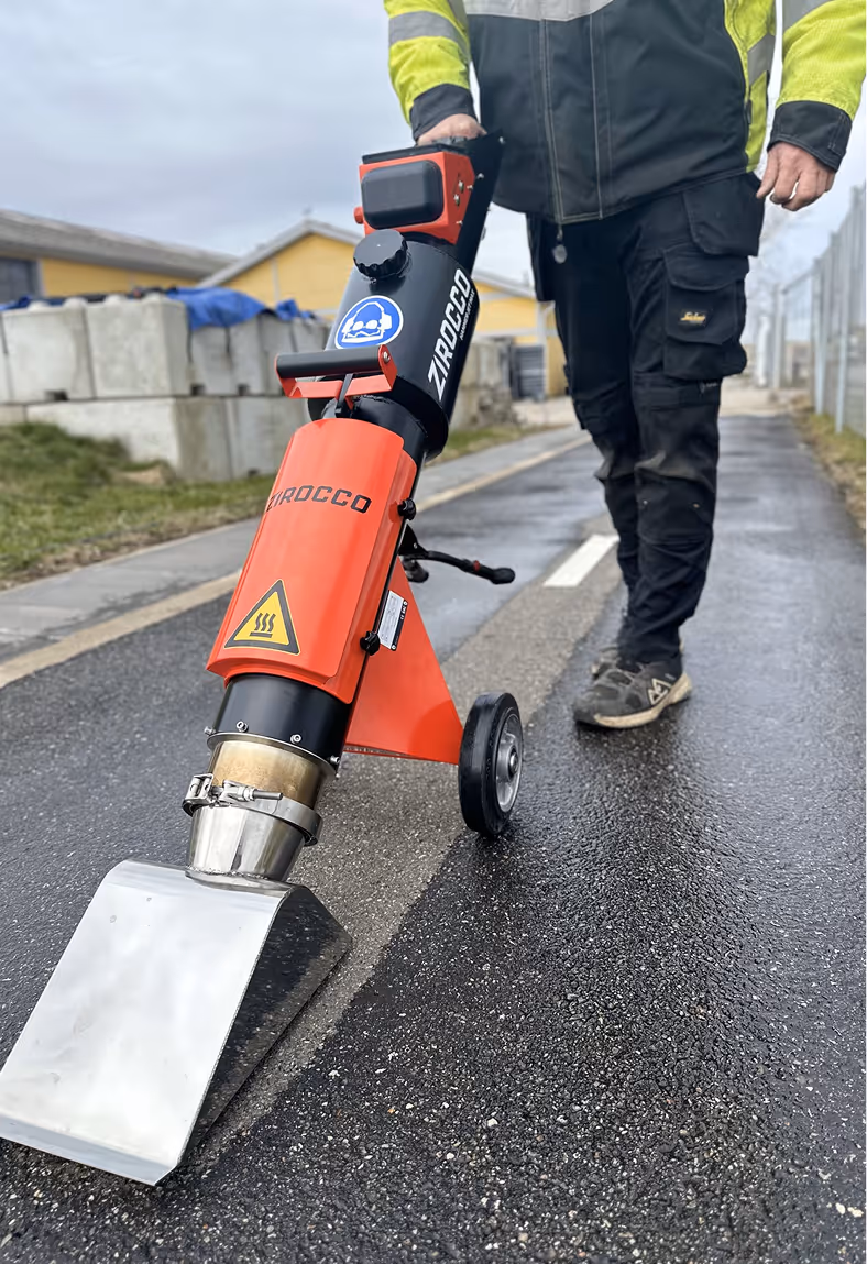 en mand tørrer asfalten med en jettørrer