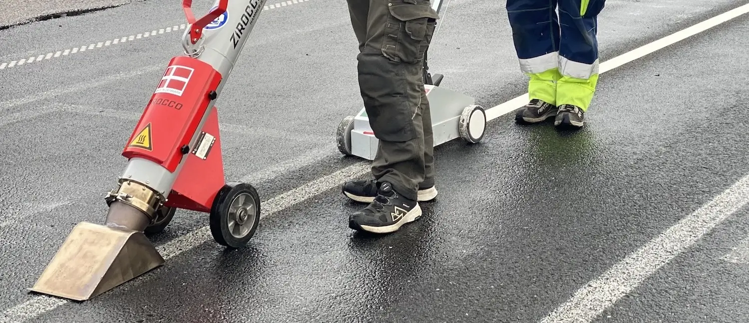 Straßenarbeiter trocknen die Fahrbahn mit dem Zirocco Hammer Jet vor dem Aufbringen der Straßenmarkierungen
