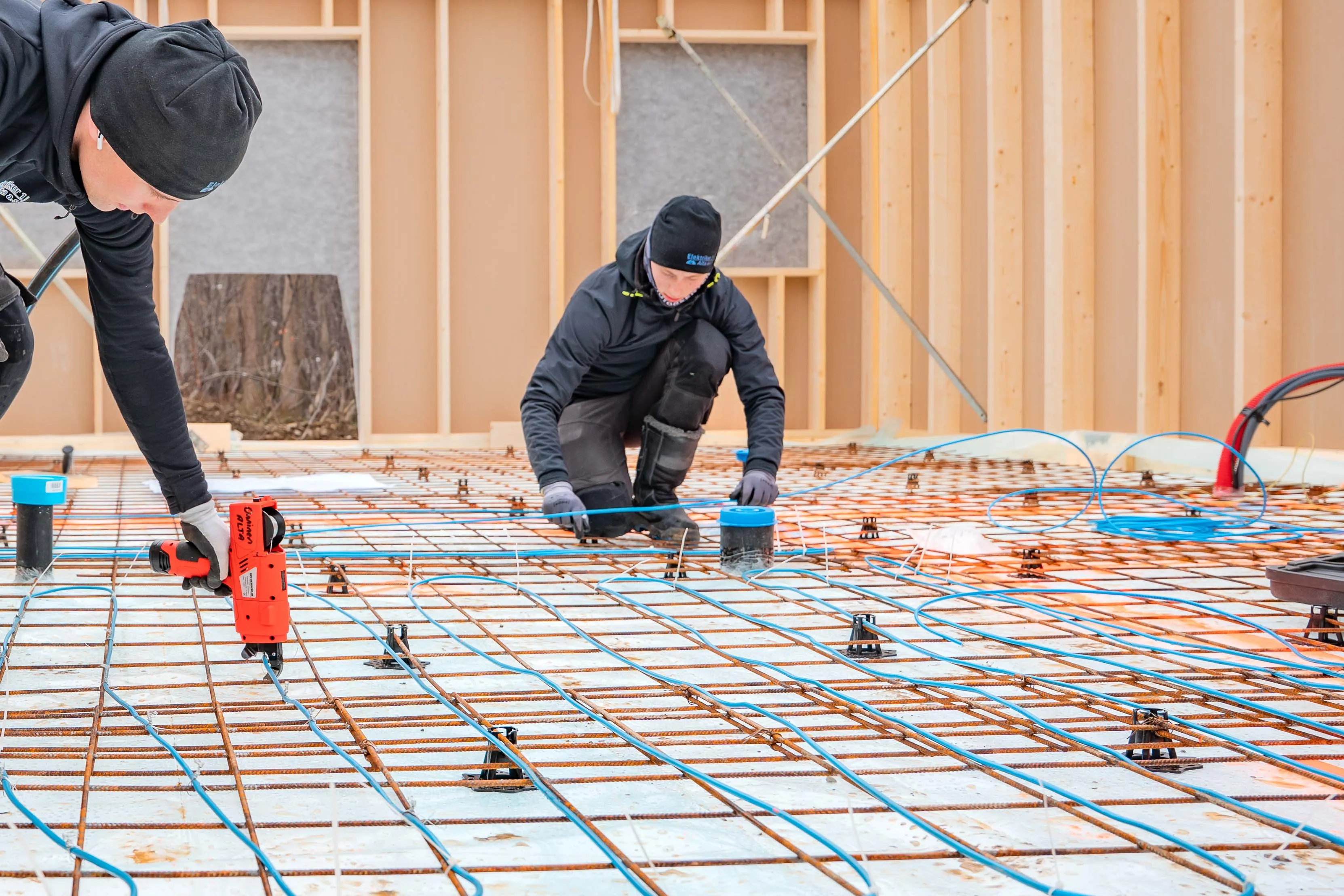 elektrikerer legger varmekabler i alta