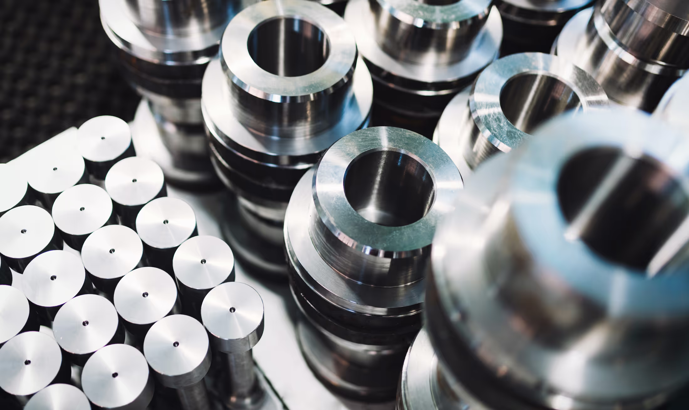 Stacks of shiny metal cylinders and discs arranged neatly on a surface.