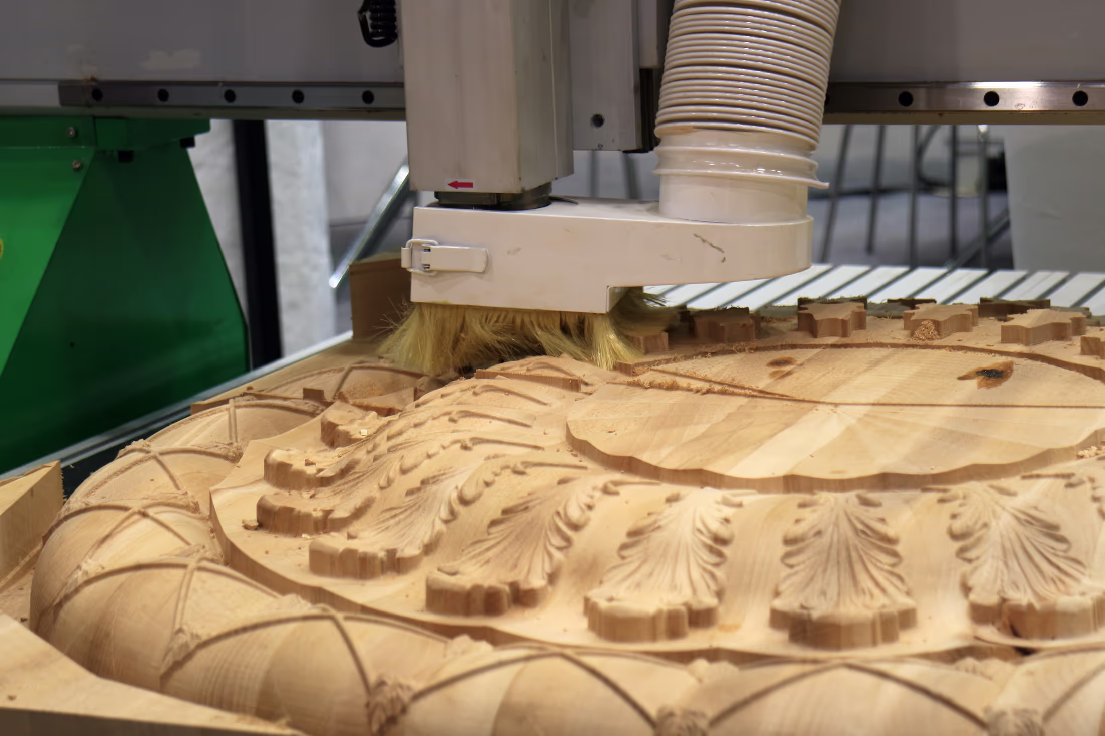 A machine carves intricate patterns into a wooden surface.