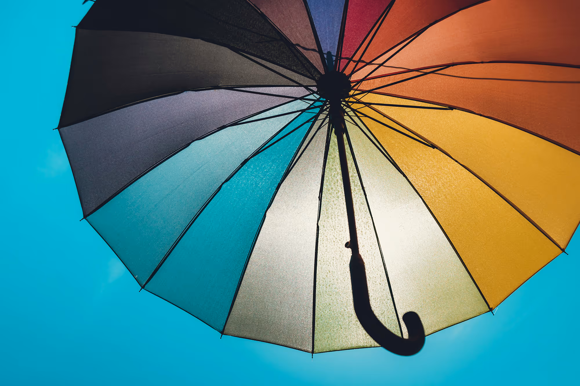 Colourful umbrella on a clear blue sky background