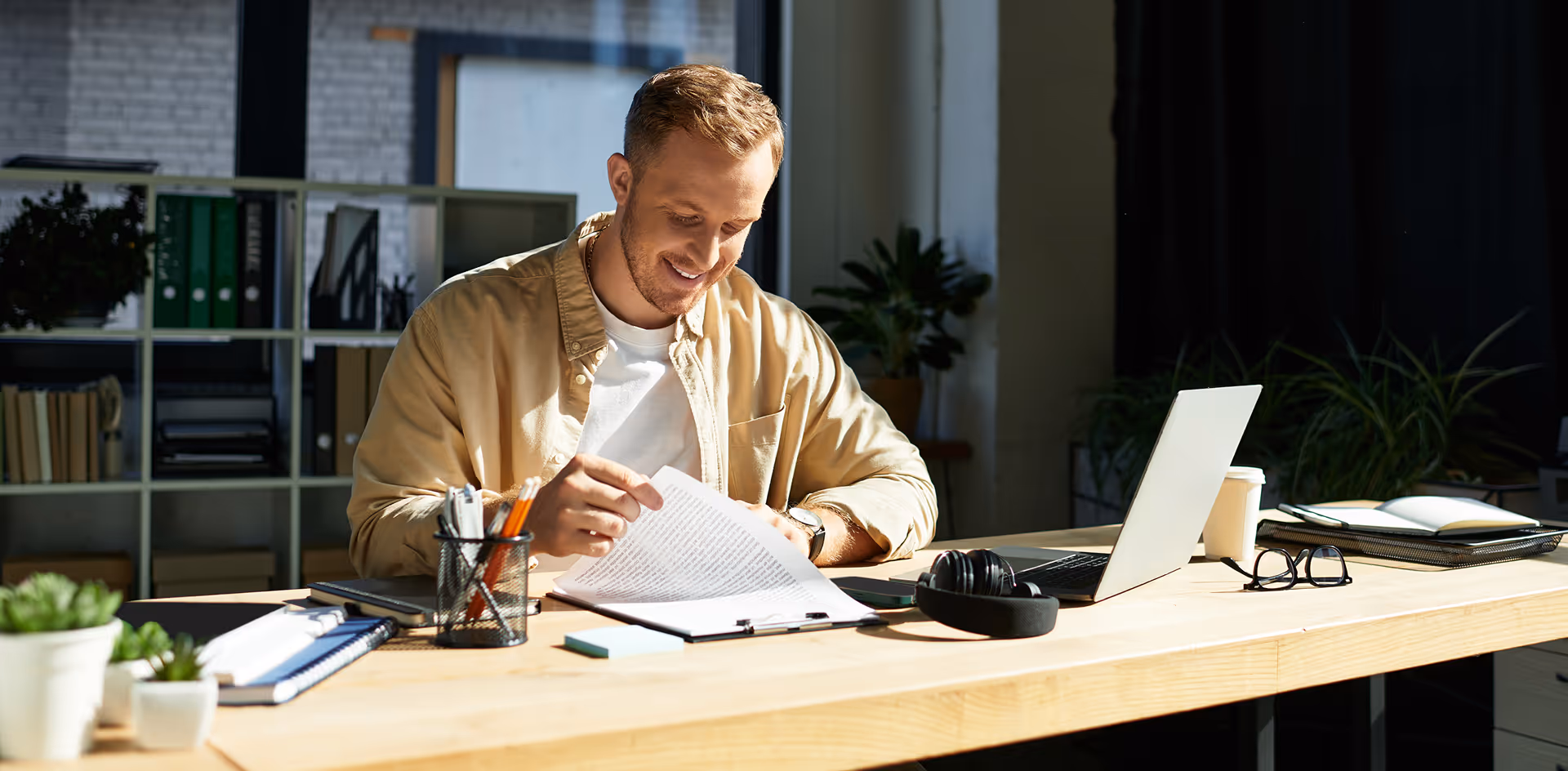 A young businessman reading a contract and smiling happily