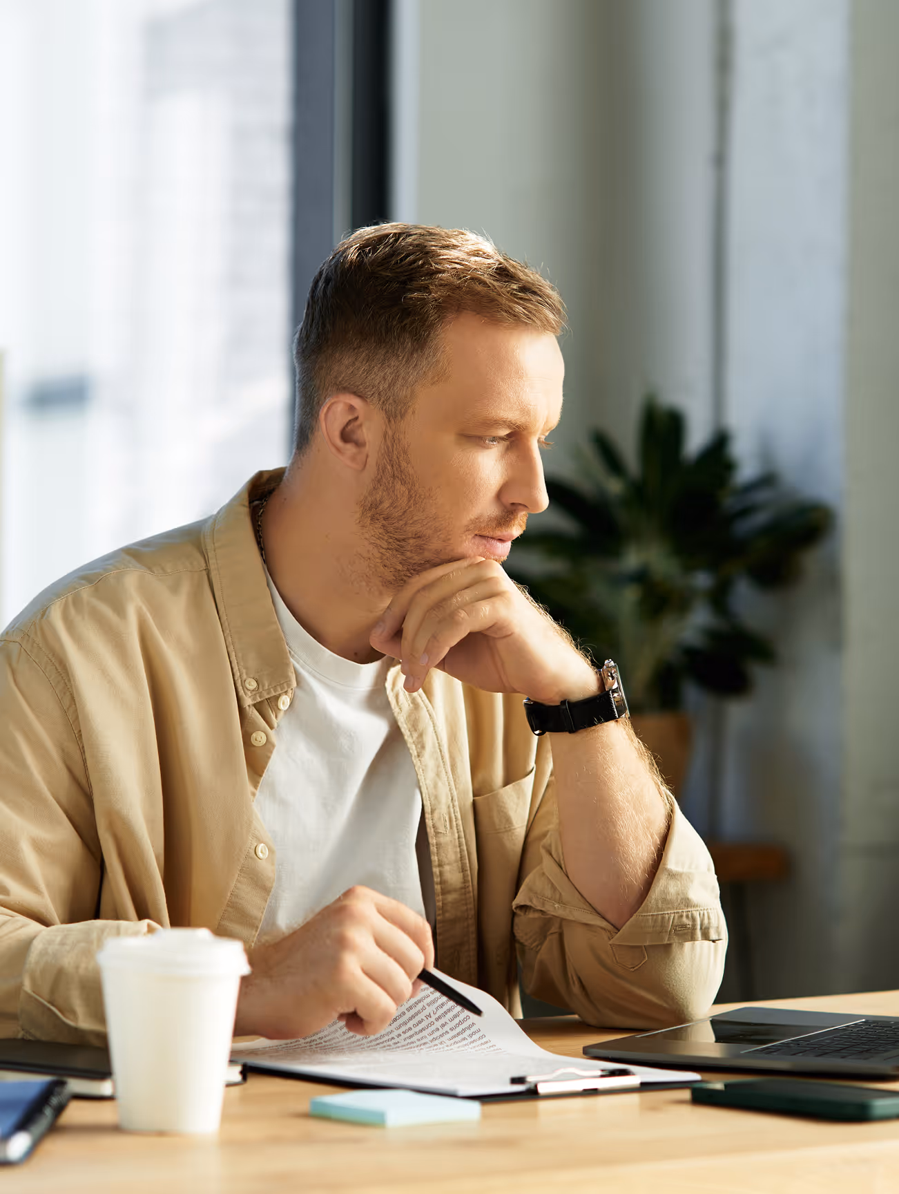 A young businessman doing research at his desk, writing things down