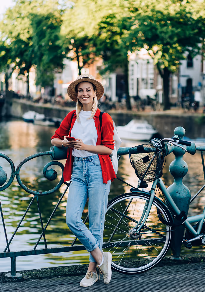 A girl posing for a photo in front of a bridge in Amsterdam