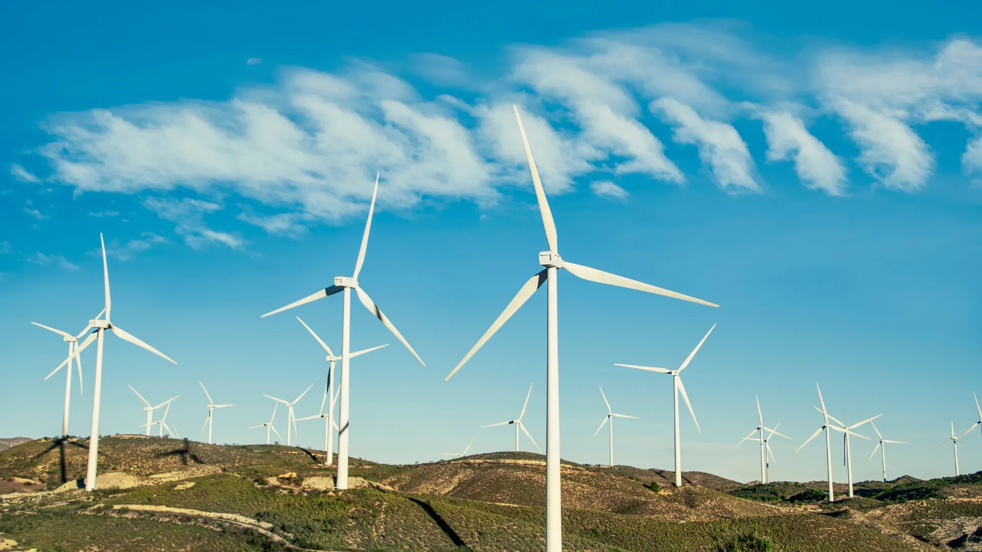 Modern wind turbines generating clean energy in an open landscape under a clear sky