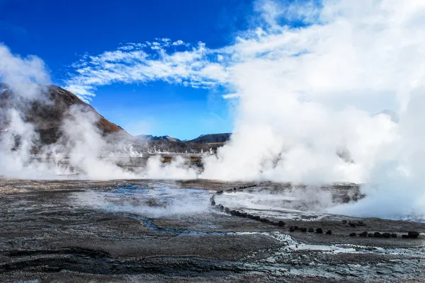 Colorful geothermal hot spring with steam rising, illustrating geothermal energy in nature