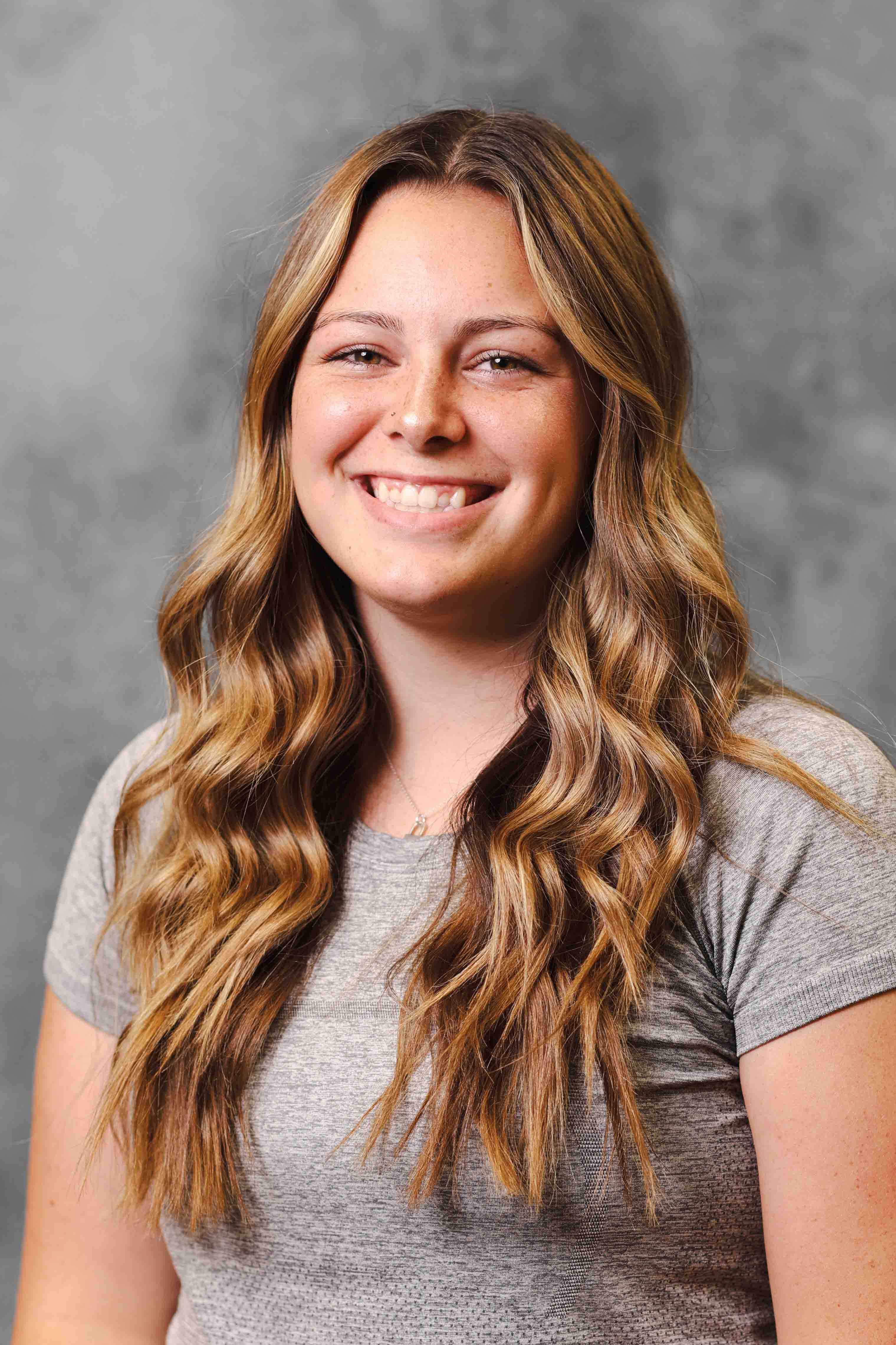 Headshot on gray backdrop of Athletic Director, Natalie Lyons.