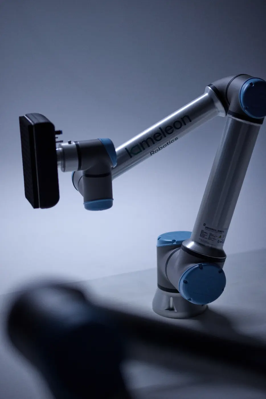 Robothånd med merkene "kameleon Robotics" og "Universal Robots" montert på et bord.