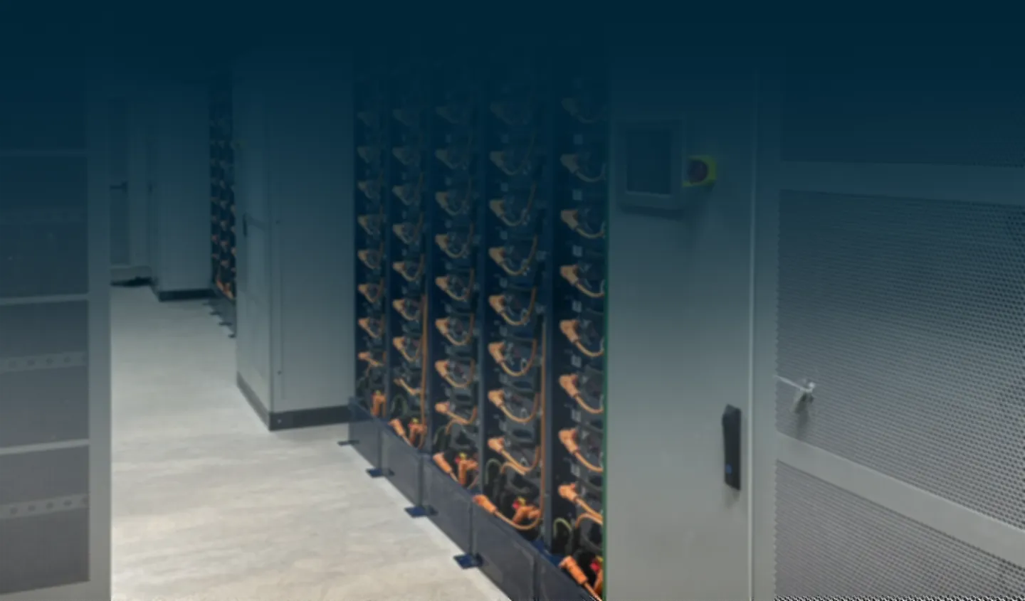 Server racks with multiple cables and a control panel in a data center room.