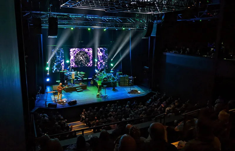 A band playing on stage at a medium sized theater venue