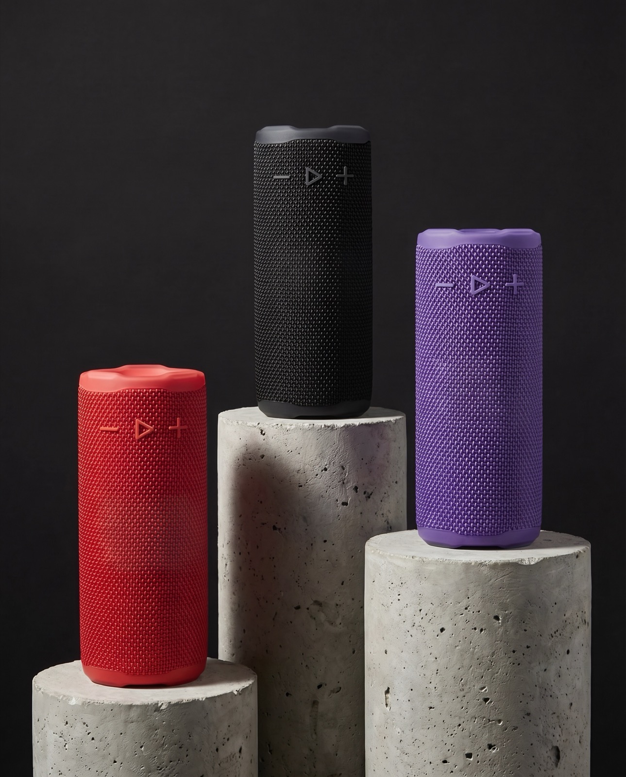 Speaker in tre colori su colonne di cemento, still life generato con l’AI