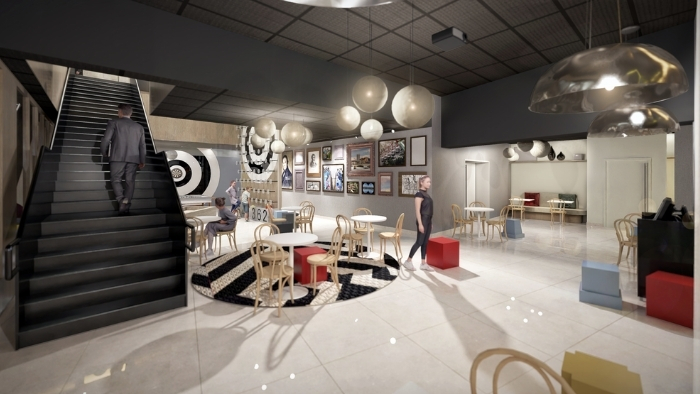 Atrium lumineux de l’hôtel YSOTOP à Grenoble, espace de vie partagé favorisant la convivialité et les échanges entre voyageurs.