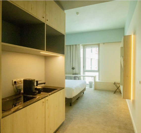 Cuisine équipée d’un appartement de l’hôtel YSOTOP à Grenoble, idéale pour un séjour autonome de moyenne ou longue durée.